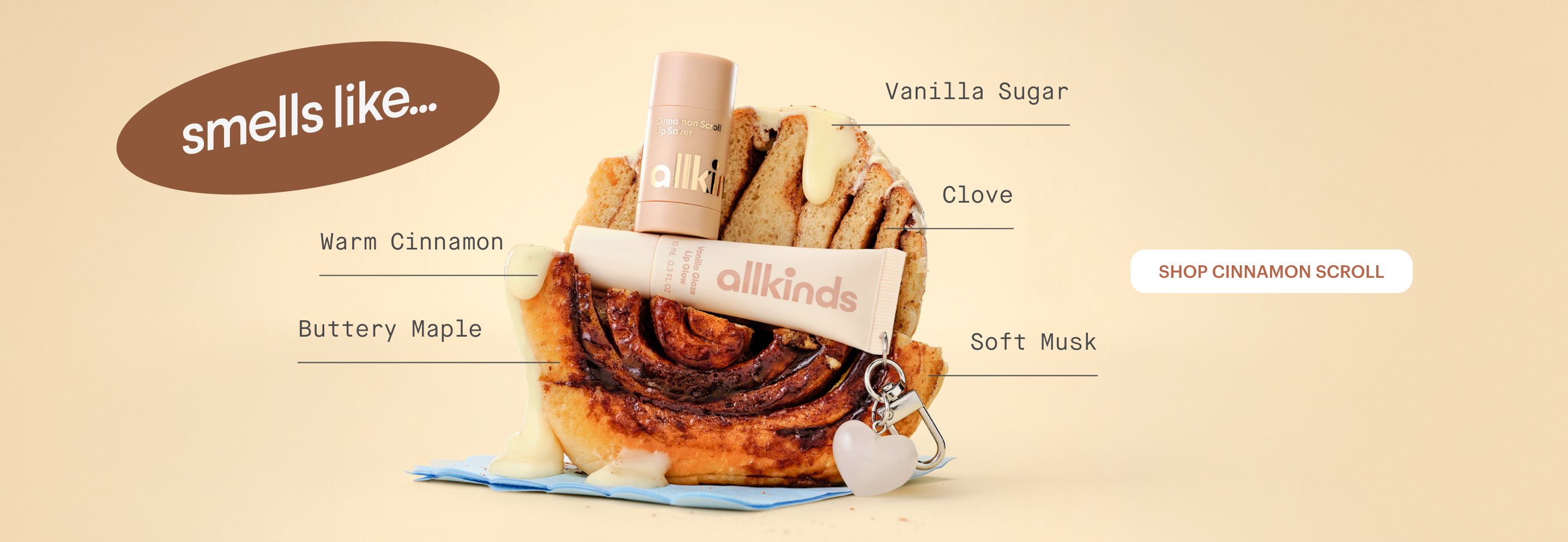 Allkinds beauty products on a glazed cinnamon roll, with text listing scent notes like Warm Cinnamon, Vanilla Sugar, and Soft Musk, and a "Shop Cinnamon Scroll" button.