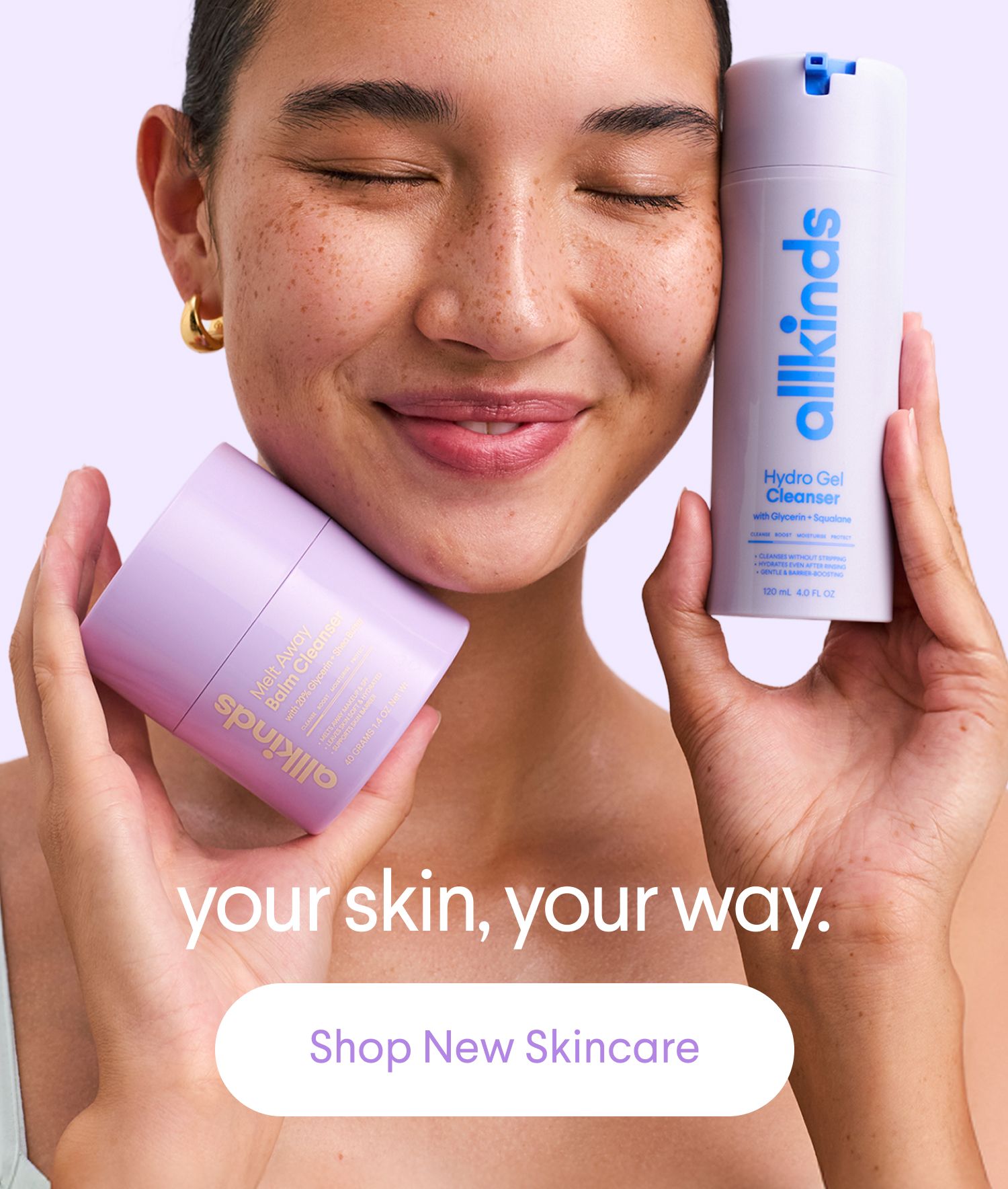 A smiling person with closed eyes holds an allkinds Melt Away Balm Cleanser and Hydro Gel Cleanser. Text reads: 'your skin, your way. Shop New Skincare'.