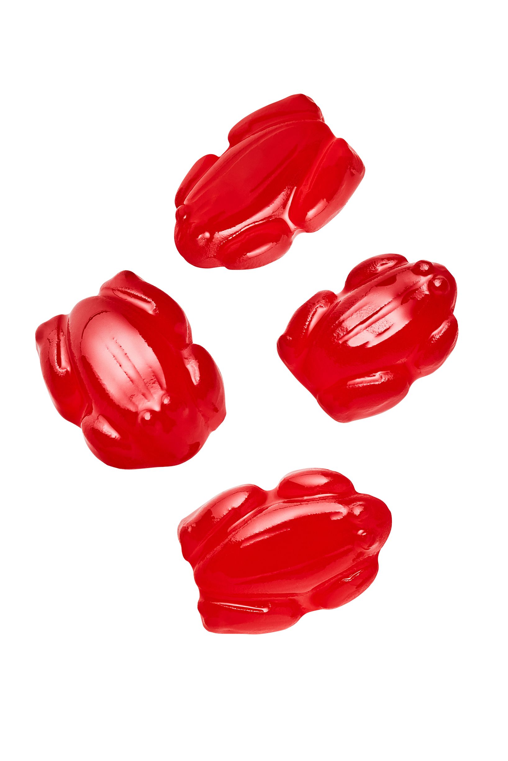 four red gummy frogs are floating in the air on a white background .