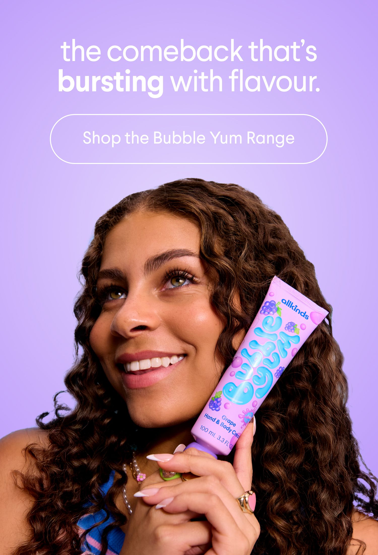 a woman with curly hair is holding a tube of silkheads bubble yum range