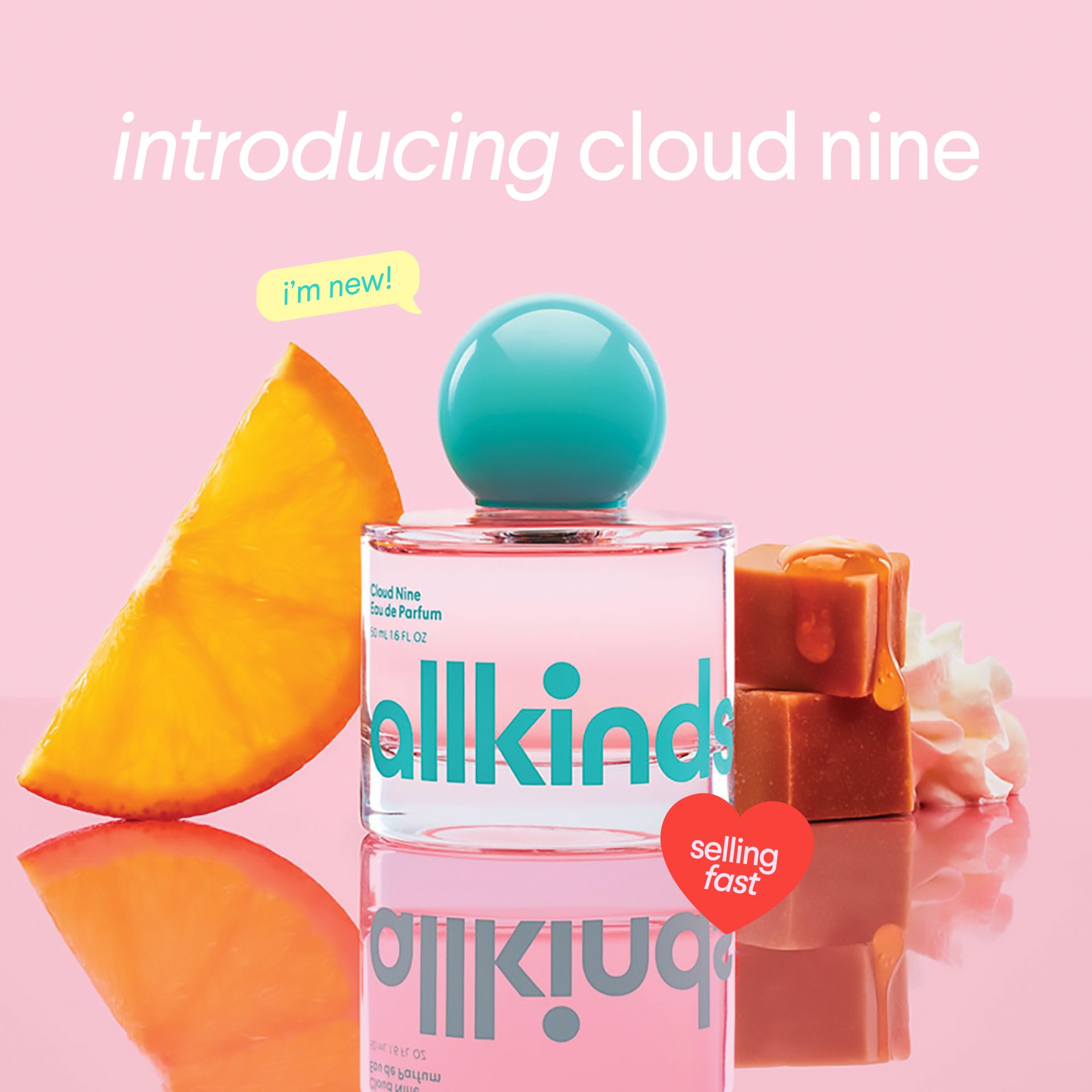 a bottle of allkind perfume is sitting on a table next to a slice of orange and caramel .