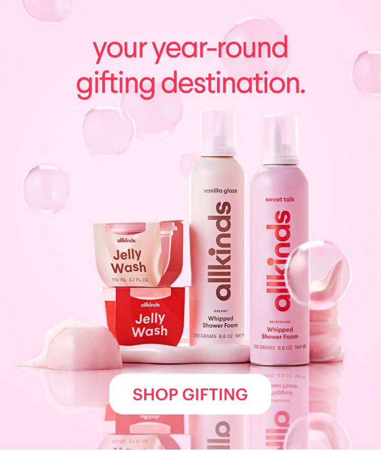 Allkinds Jelly Wash and Whipped Shower Foam products in pink and red packaging, displayed on a pink background with bubbles, promoting "your year-round gifting destination." and a "SHOP GIFTING" button.