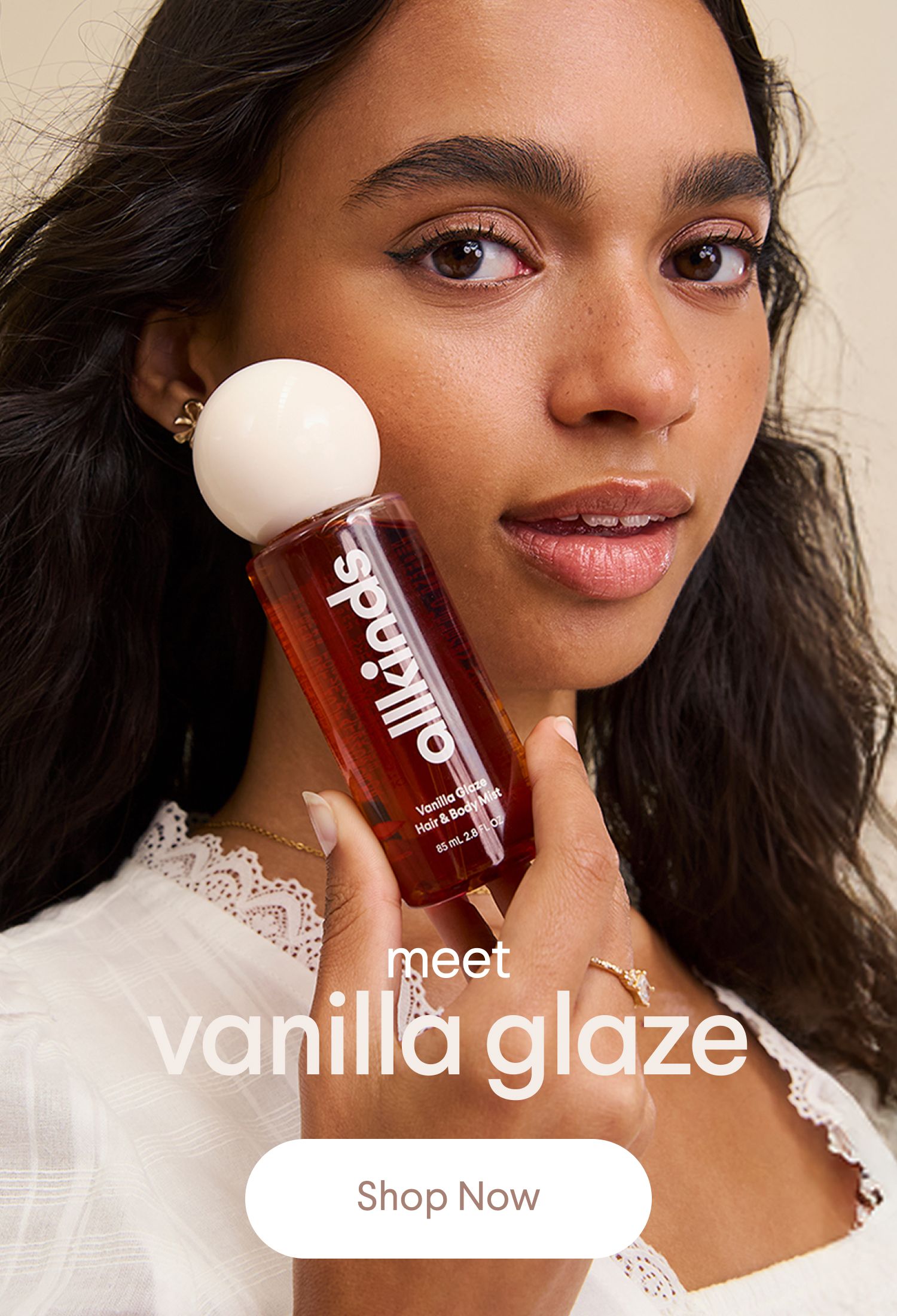 A woman with long dark hair holds an Allkinds Vanilla Glaze Hair & Body Mist bottle. Text says "meet vanilla glaze" and "Shop Now".