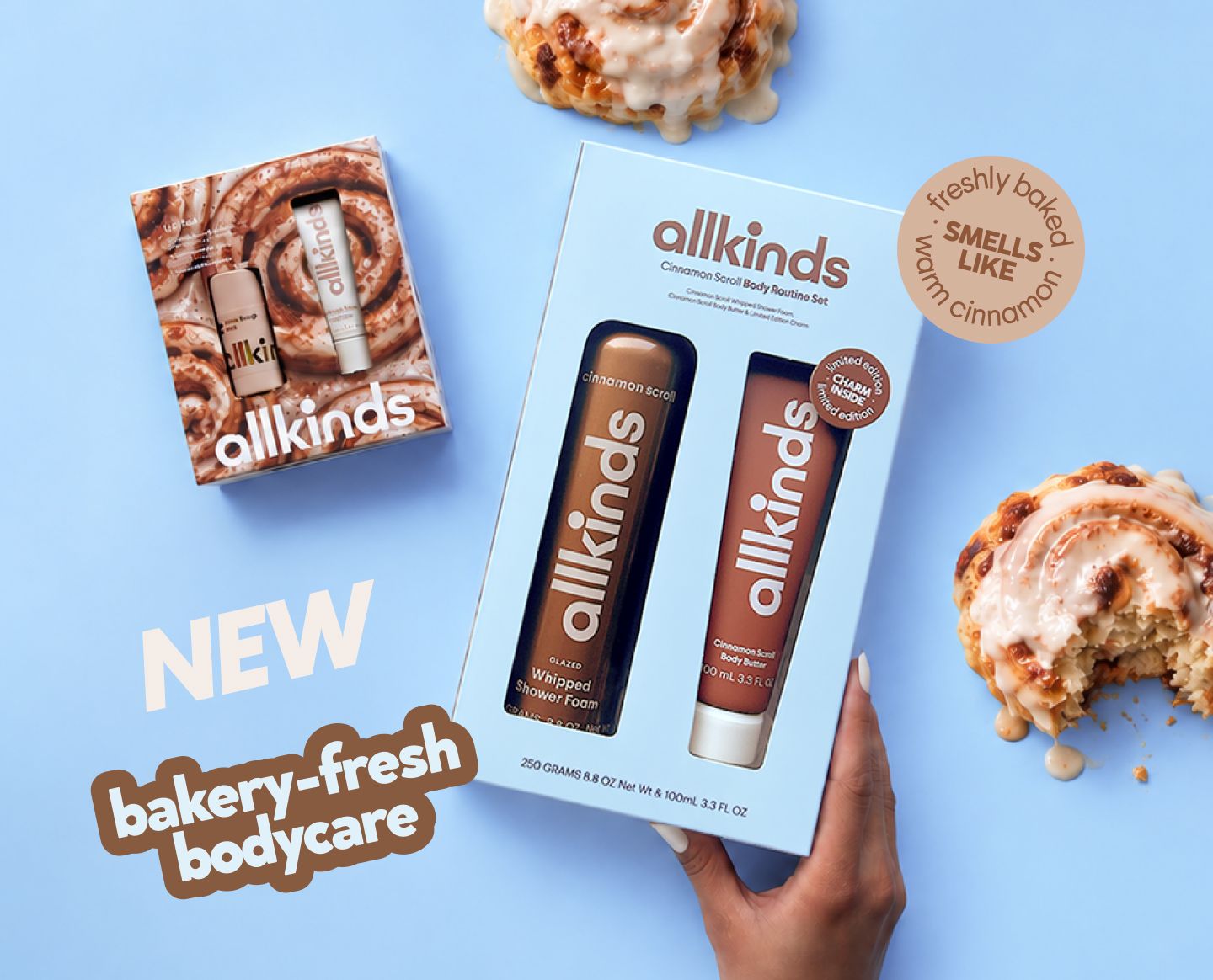 Allkinds cinnamon-scented body care sets, packaged like cinnamon rolls, alongside real cinnamon rolls on a blue background. Text: "bakery-fresh bodycare" and "smells like warm cinnamon."