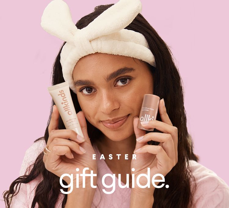 A woman wearing a bunny ear headband holds two Allkinds lip products. Text: EASTER gift guide.