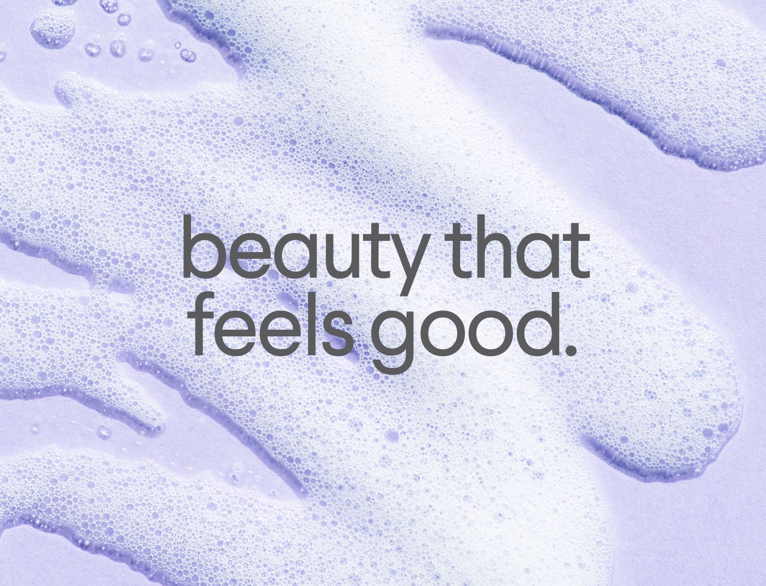 Lavender foam on a purple background with the text "beauty that feels good."