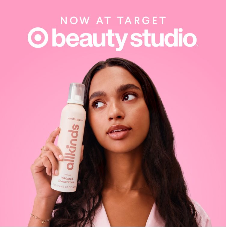 A woman holds a bottle of allkinds Vanilla Glaze Whipped Shower Foam. Text: NOW AT TARGET beauty studio.