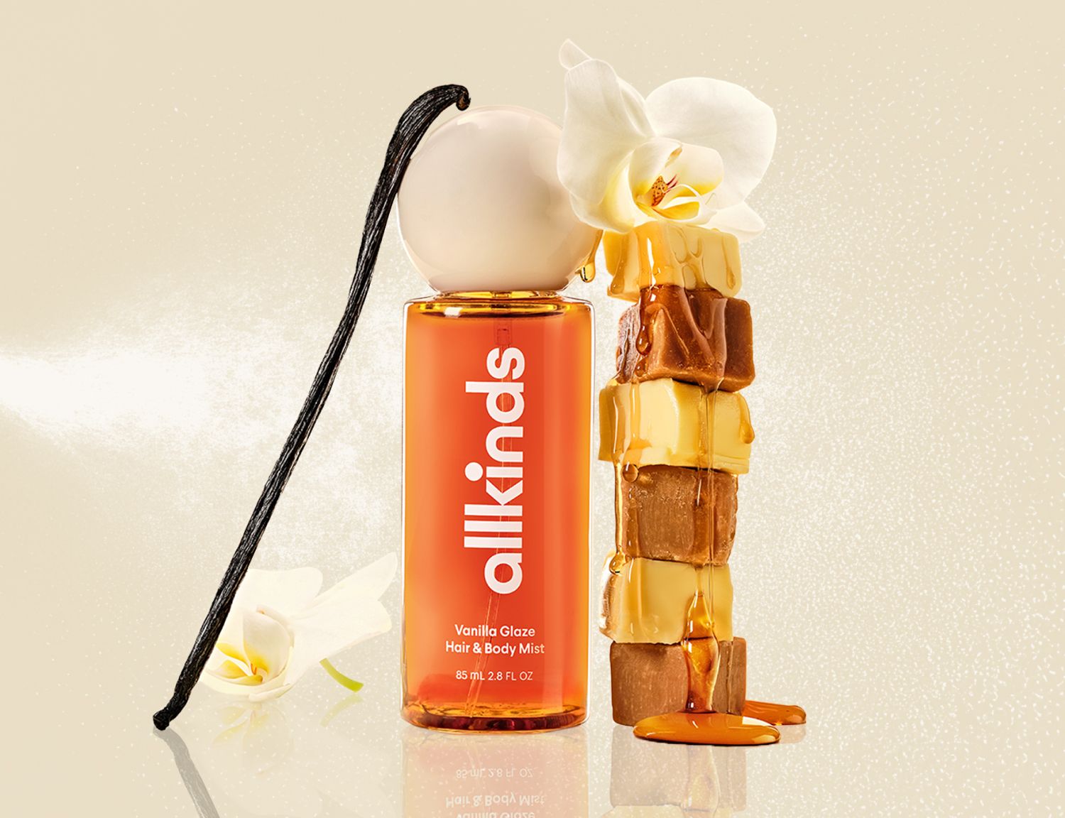 Allkinds Vanilla Glaze Hair & Body Mist bottle with a vanilla bean, stacked caramels, and an orchid.