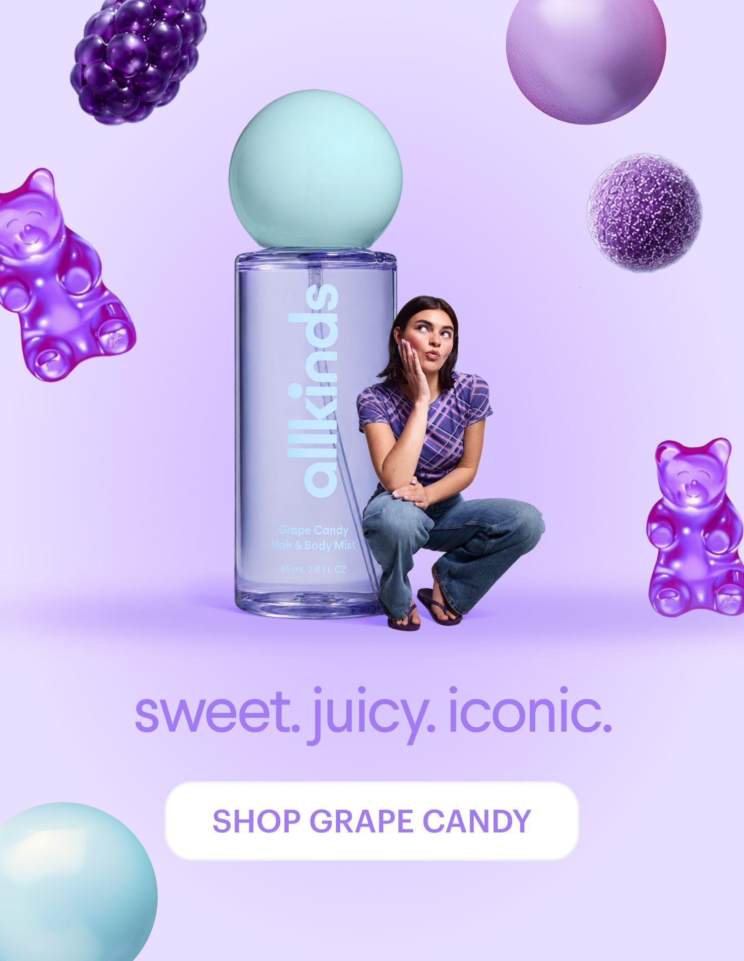 A bottle of allkinds Grape Candy Hair & Body Mist with a woman, surrounded by floating purple gummy bears and grape-like spheres on a lavender background.