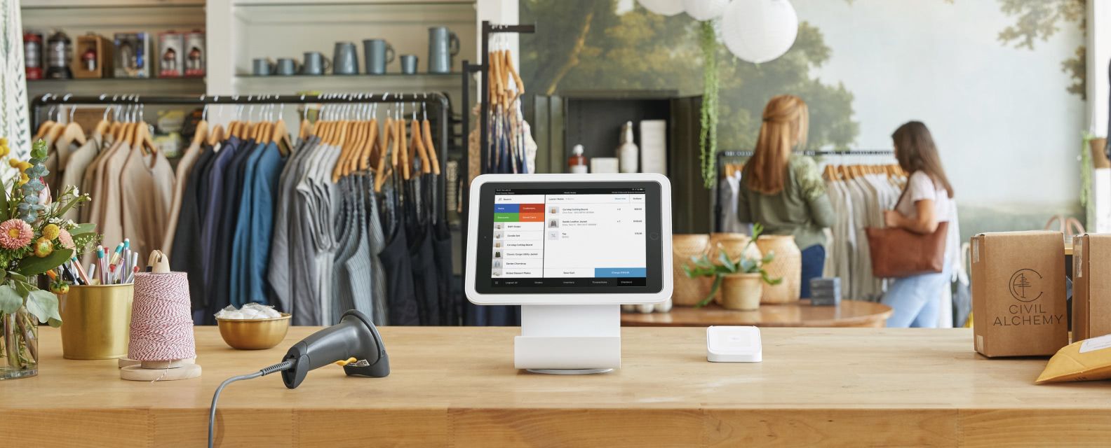 Square checkout terminal sitting on a wood checkout counter in a clothing boutique