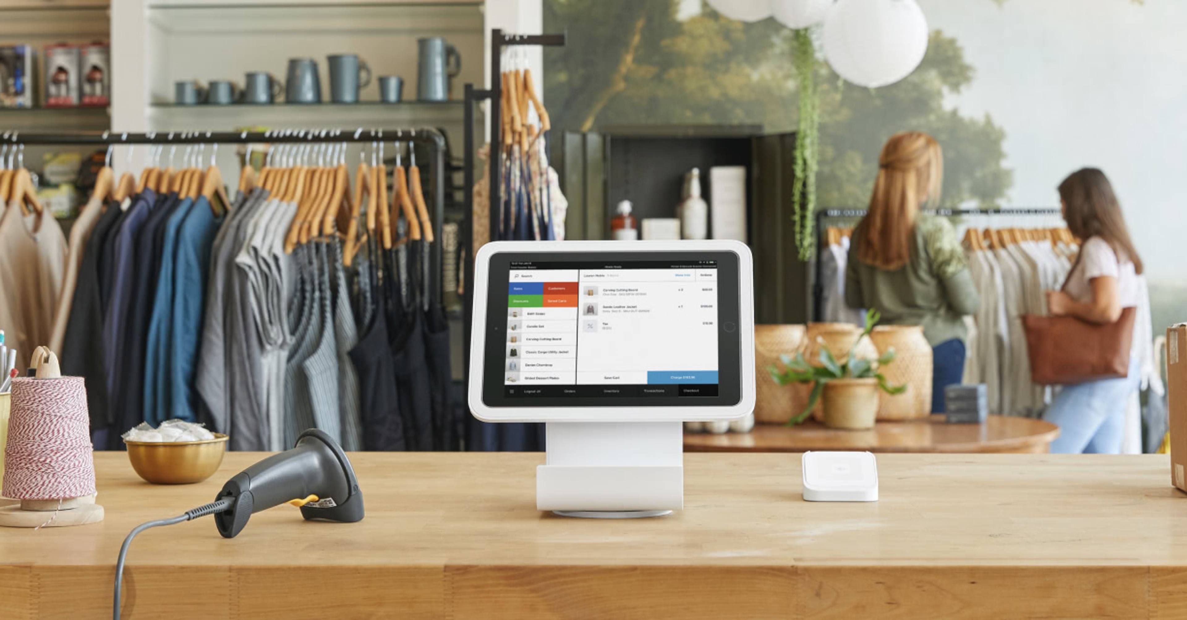 Square checkout terminal sitting on a wood checkout counter in a clothing boutique