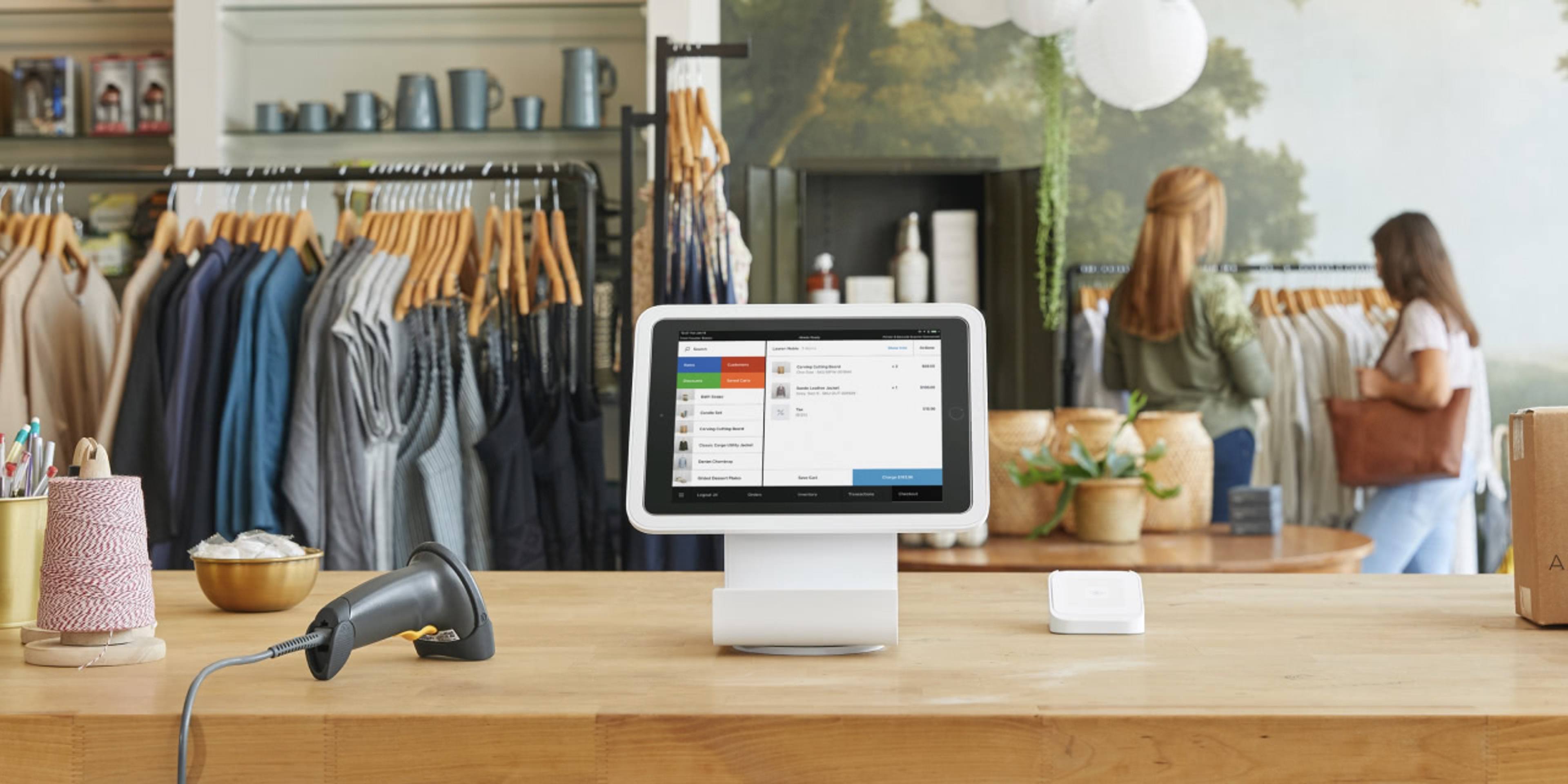 Square checkout terminal sitting on a wood checkout counter in a clothing boutique