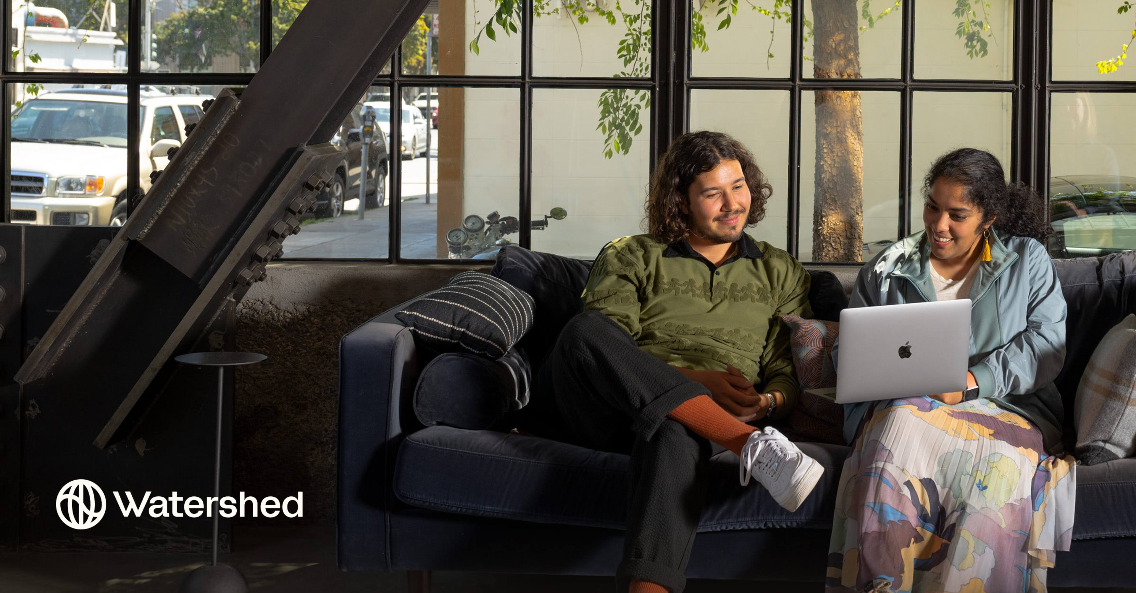 Two Watershed employees sitting on a couch at the San Francisco office