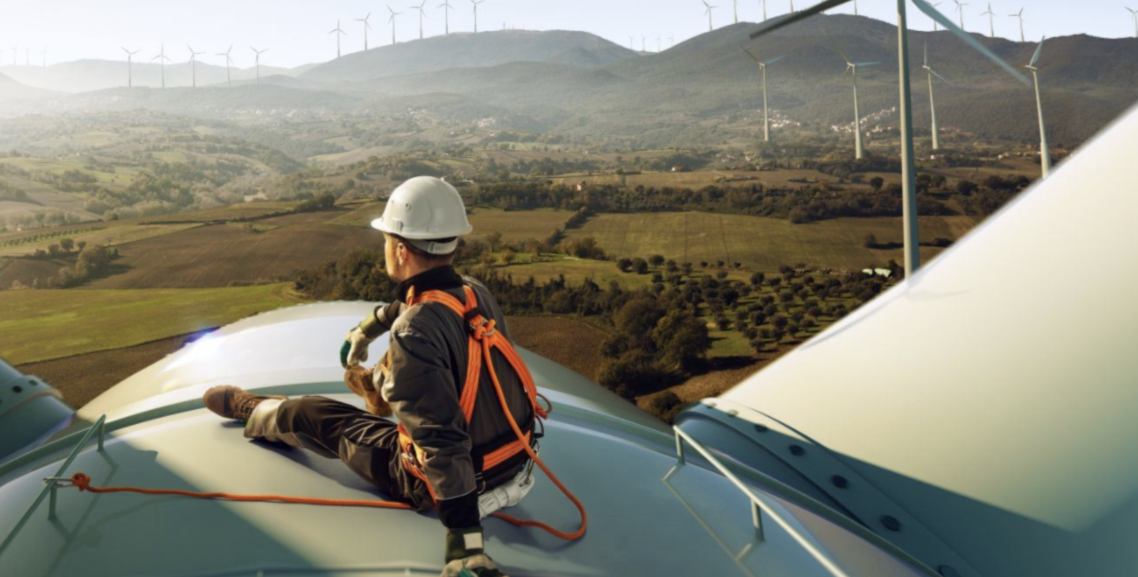 Construction worker looking at windmills