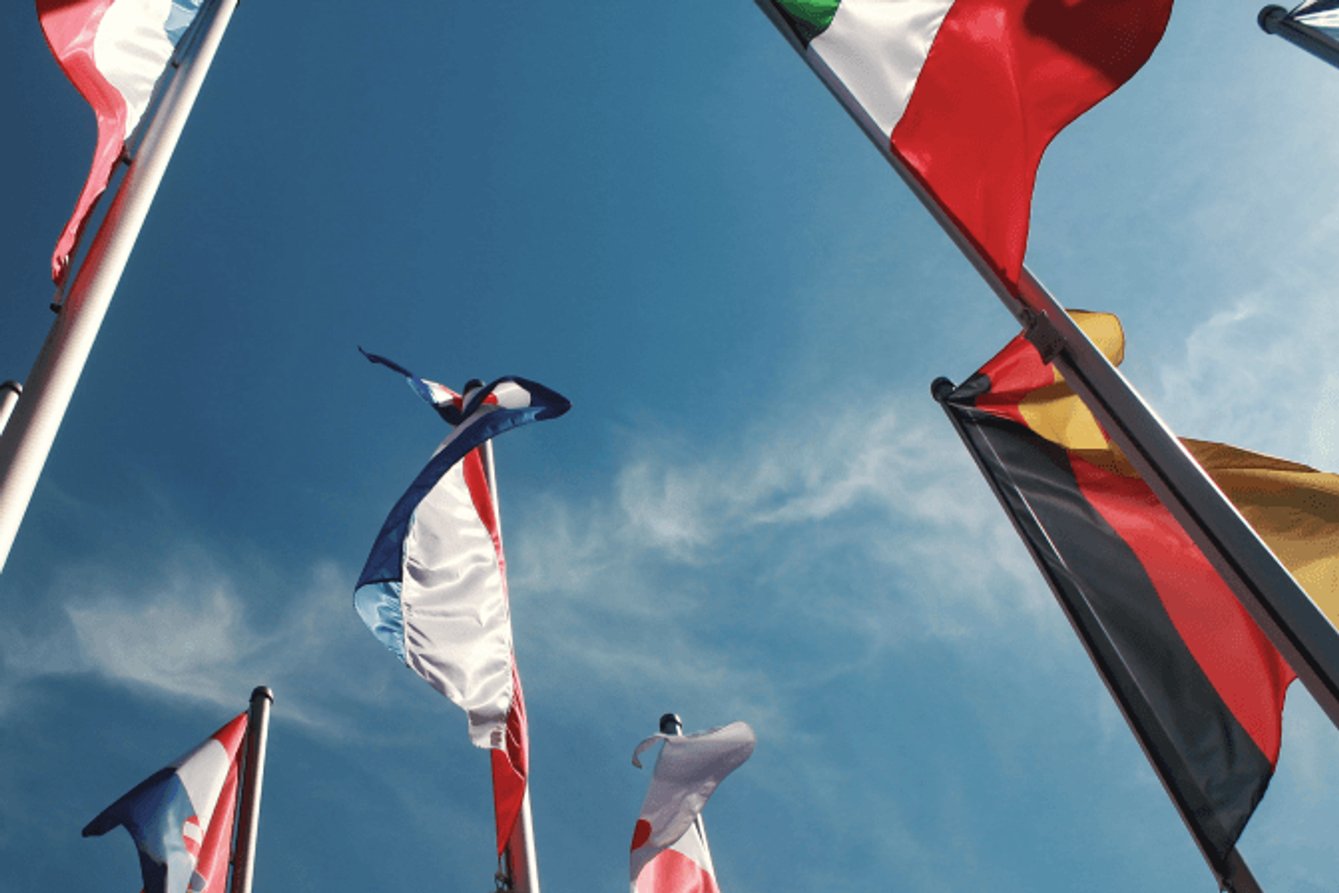 European national flags waving against a blue sky