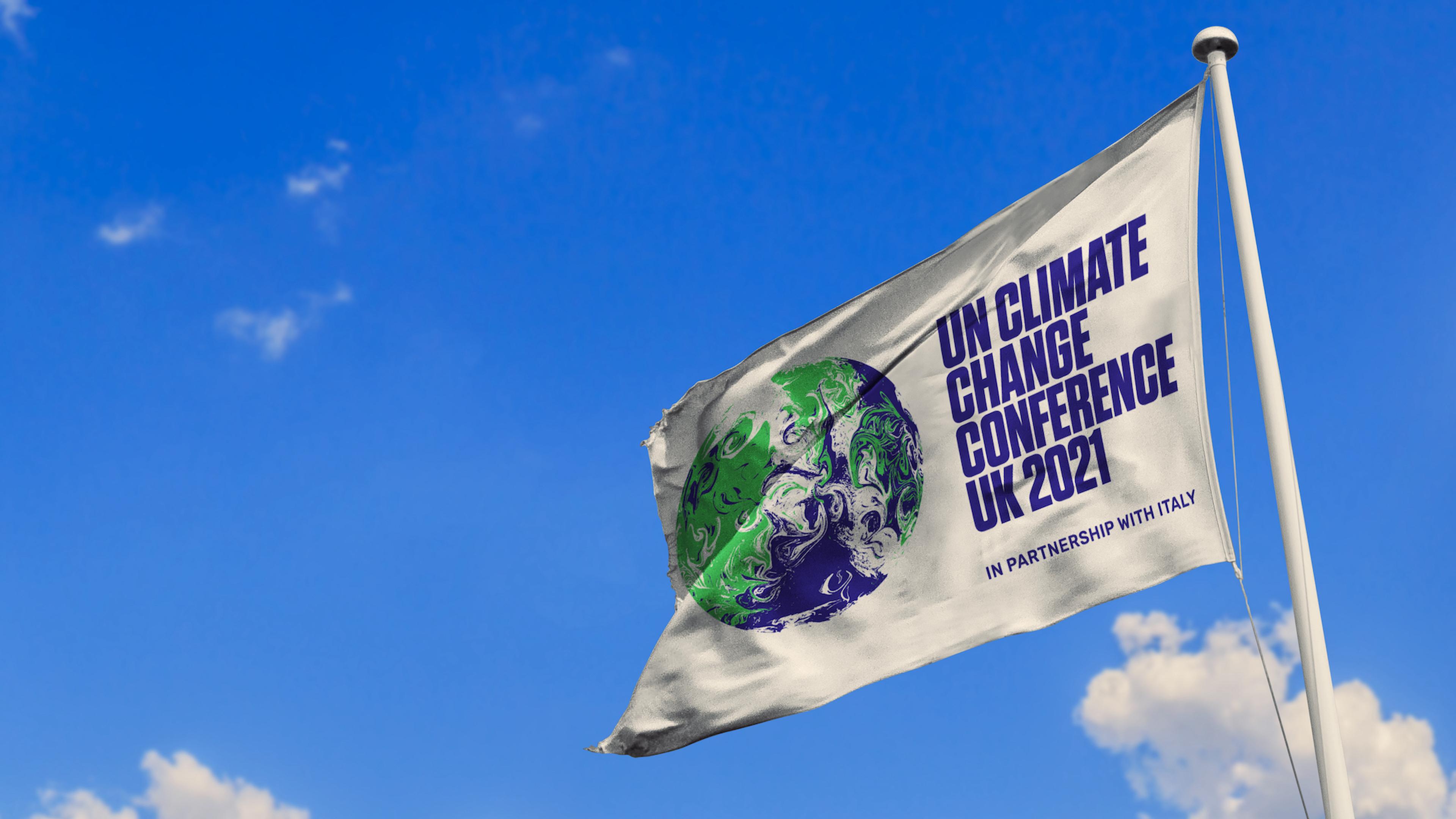 UN Climate Conference flag flying at the top of a flagpole in front of a bright blue sky