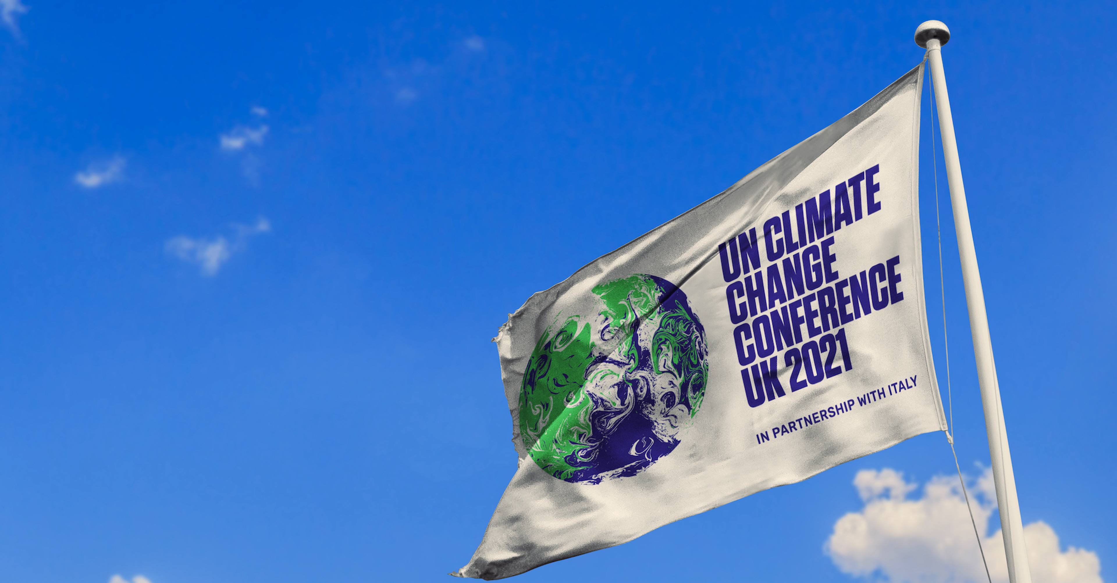 UN Climate Conference flag flying at the top of a flagpole in front of a bright blue sky