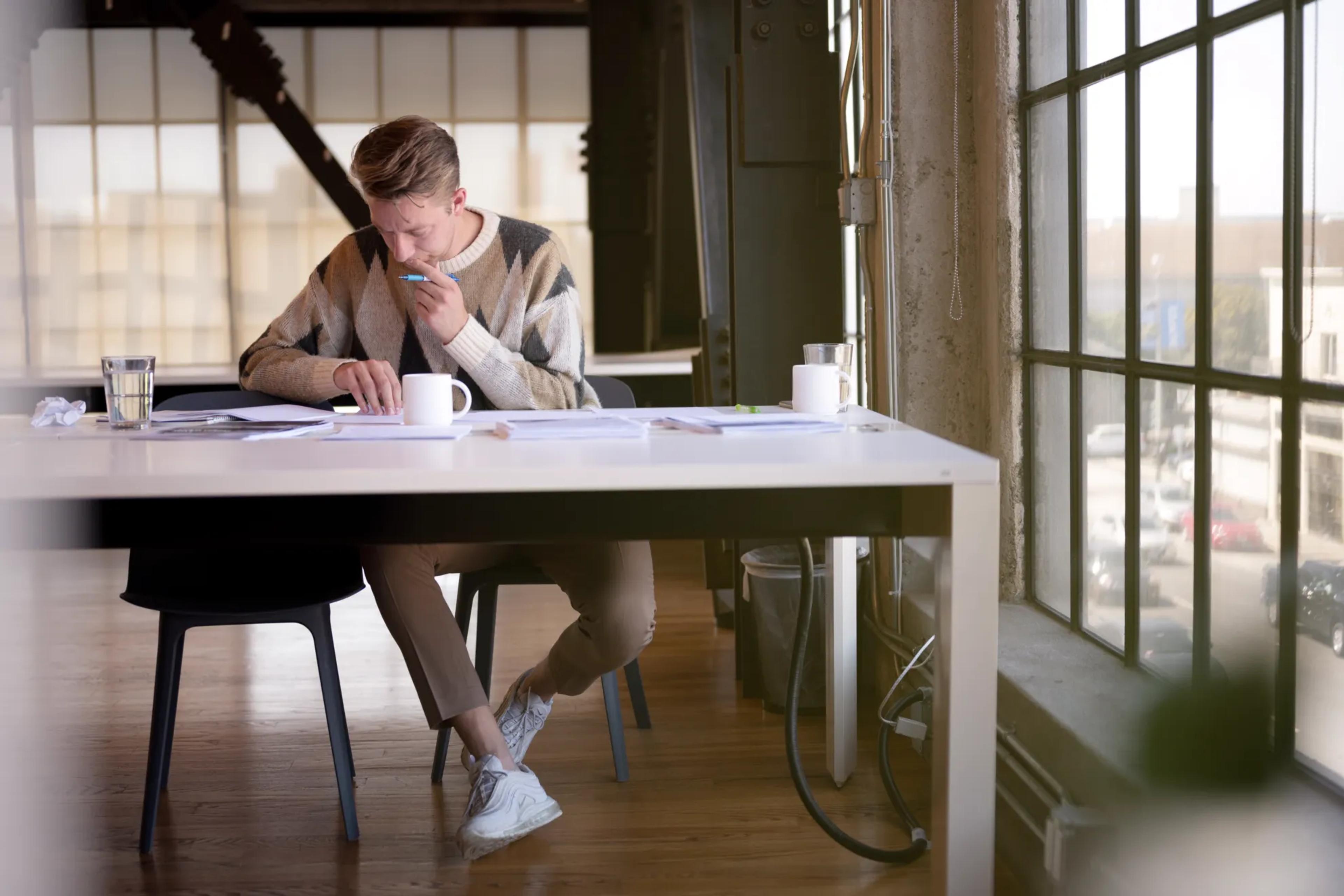 British man in sweater working on papers