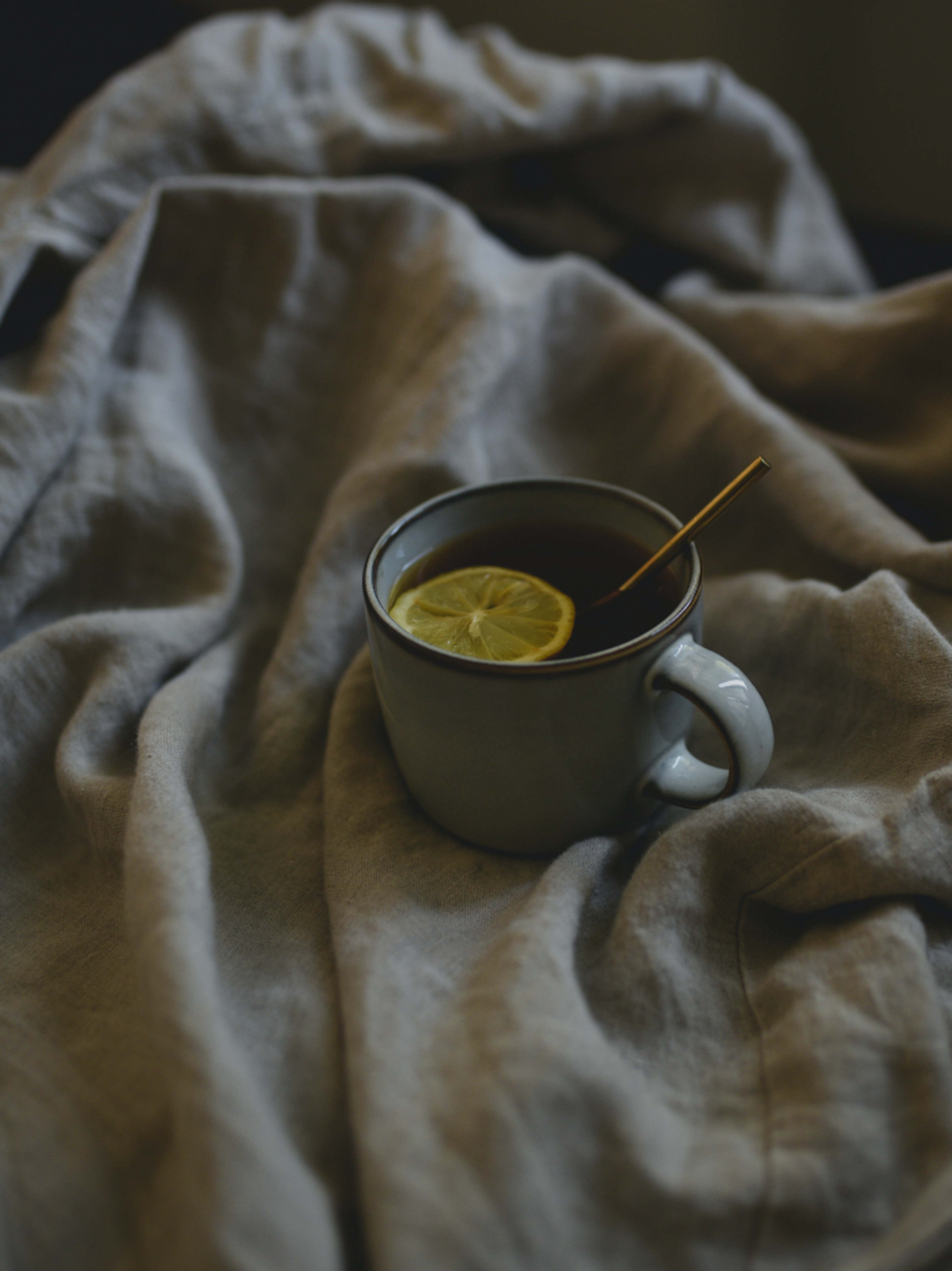 A mug of lemon tea on a linen throw