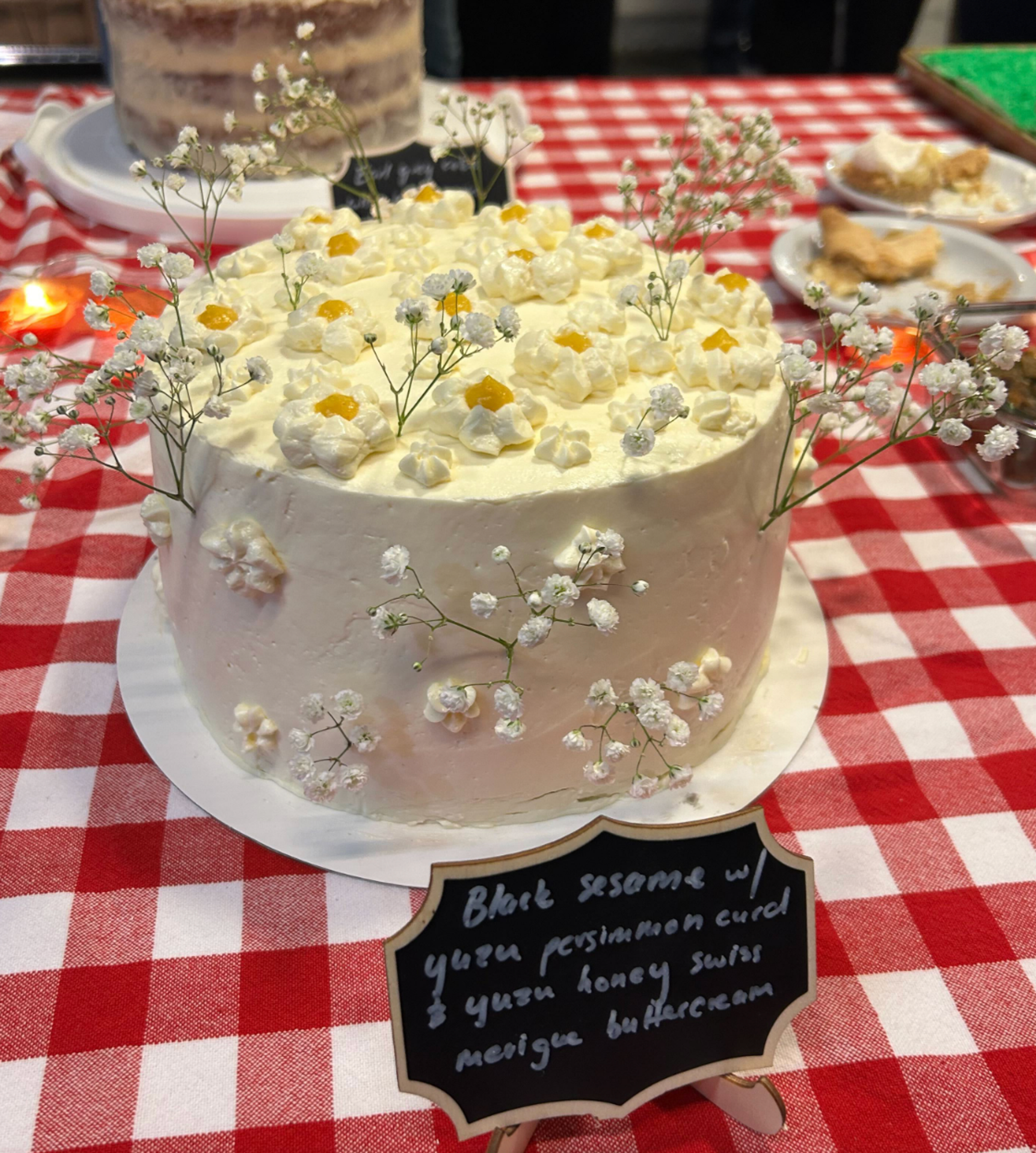 A black sesame cake with a yuzu-persimmon curd and yuzu-honey swiss meringue buttercream.