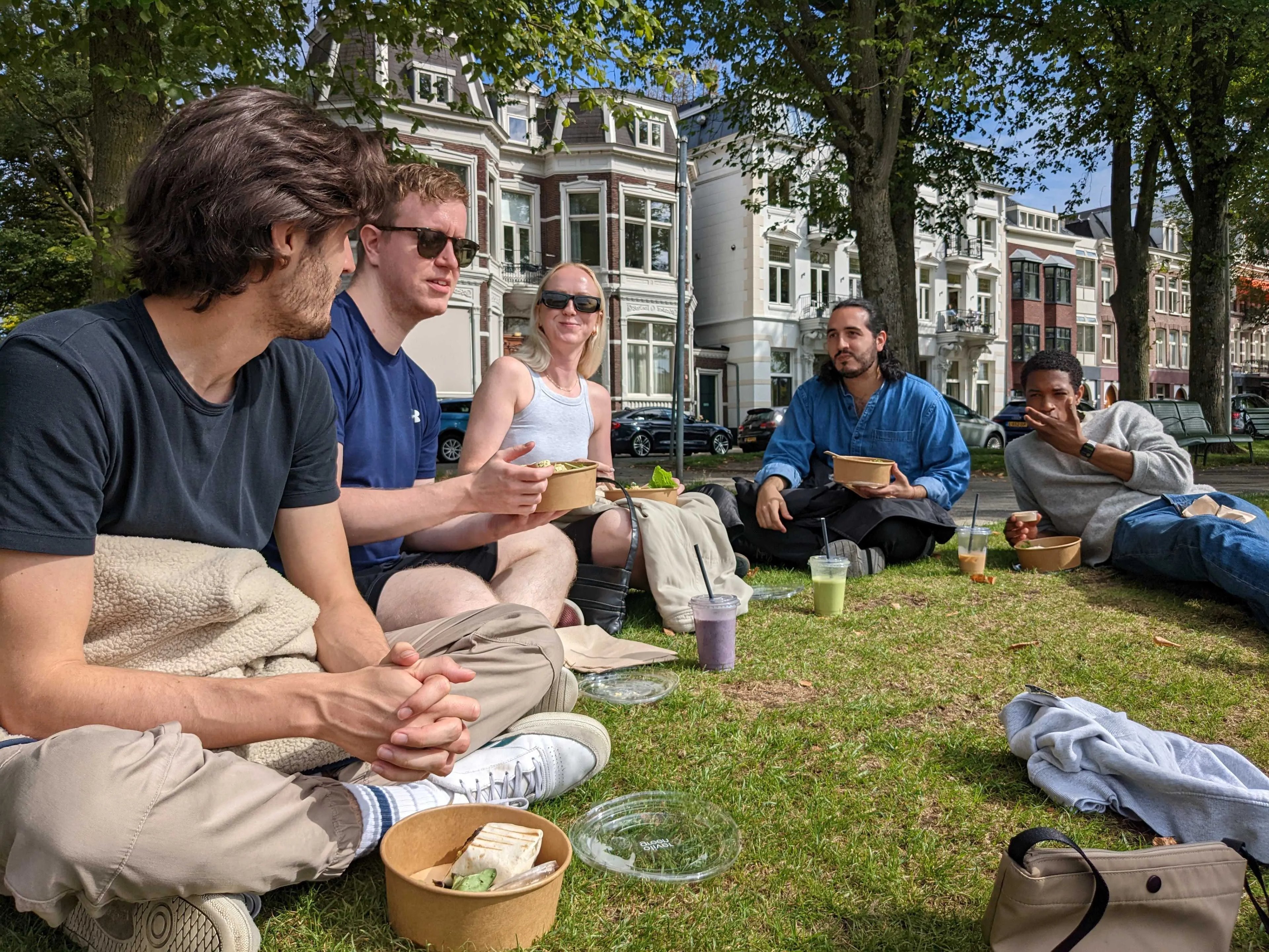 Dark blue team eating lunch by a canal in Amsterdam