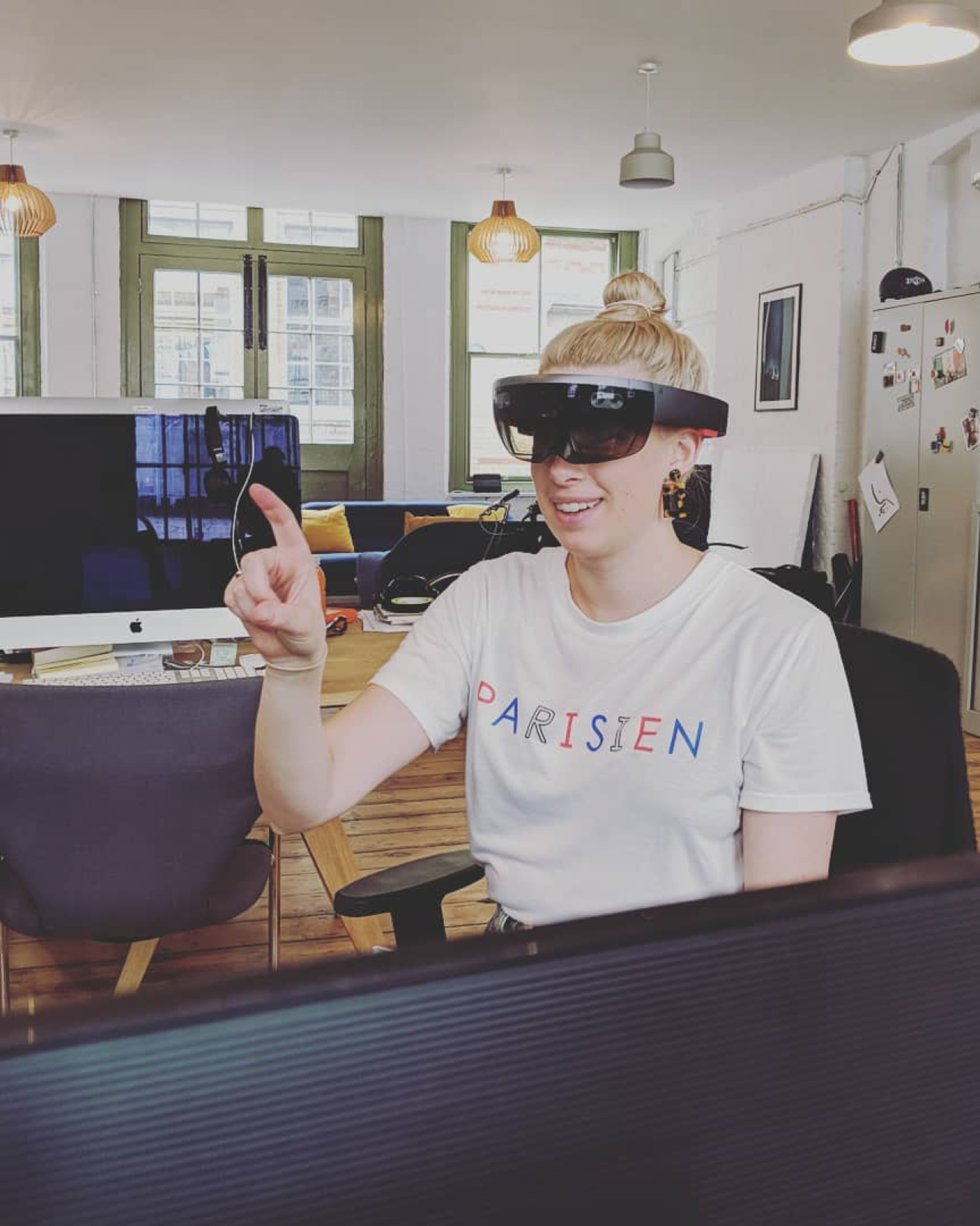 A team member wearing a mixed-reality headset, reaching out to something only they can see. Virtual and augmented reality, AI & Emerging Technology.