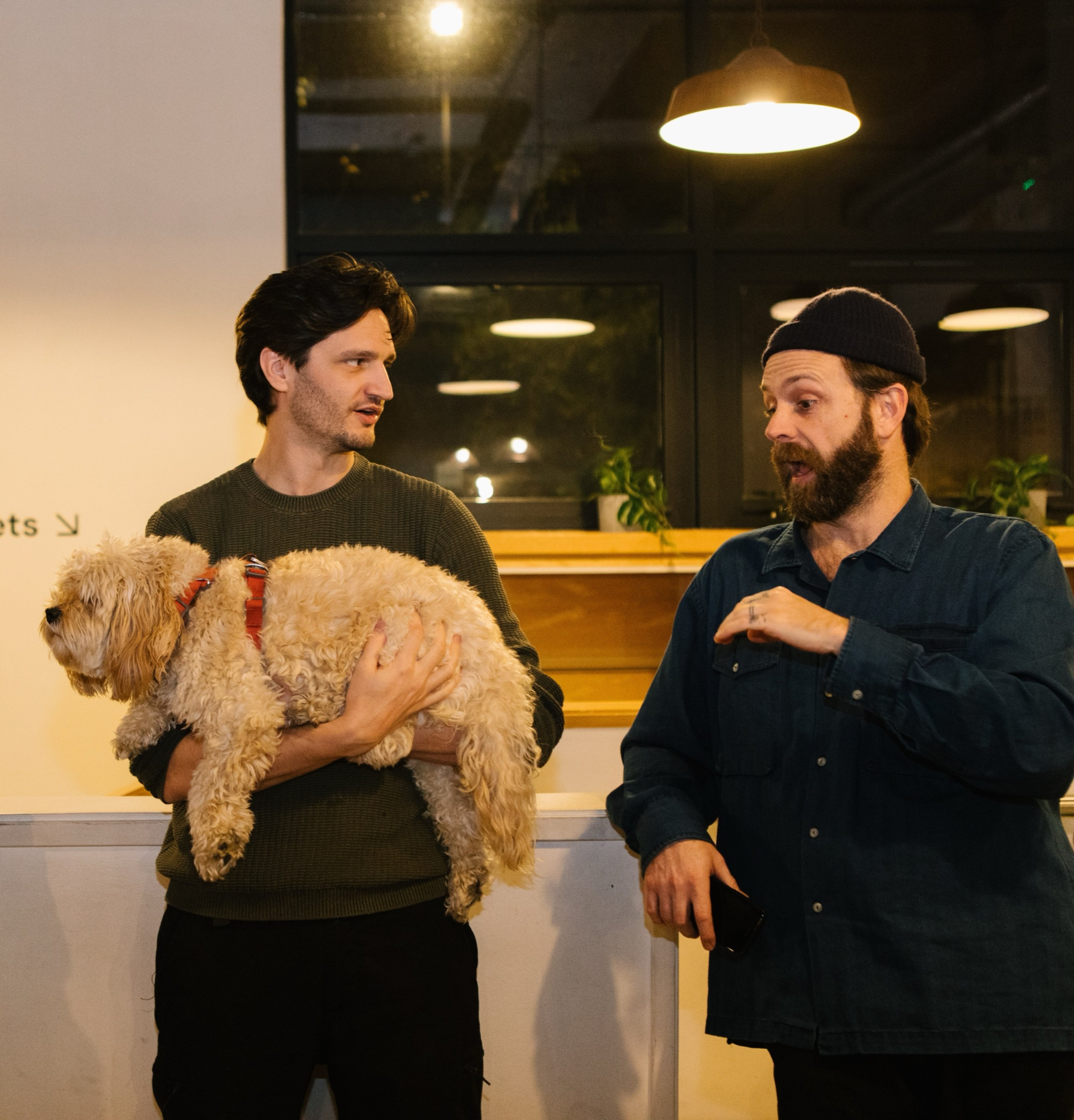 Two guests chatting at INTERFACE, one holding a fluffy dog