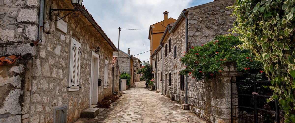A narrow lane between stone houses in an alpine village