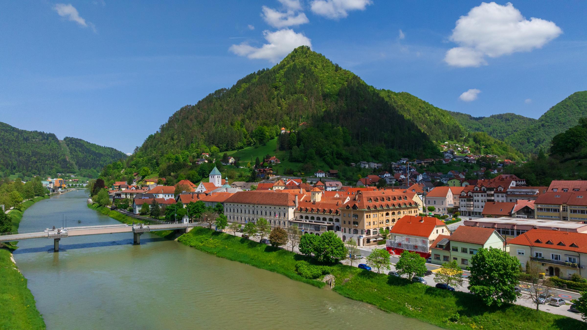 Laško and its stone bridge over the emerald Savinja river from above