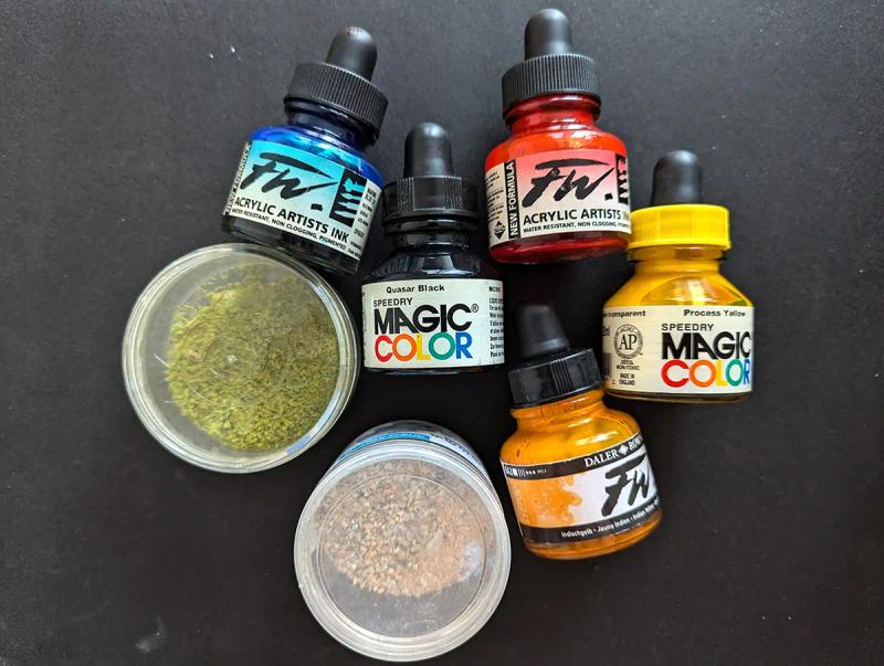 Five dropper bottles of acrylic ink and two small pots of hobby grass texture and sand