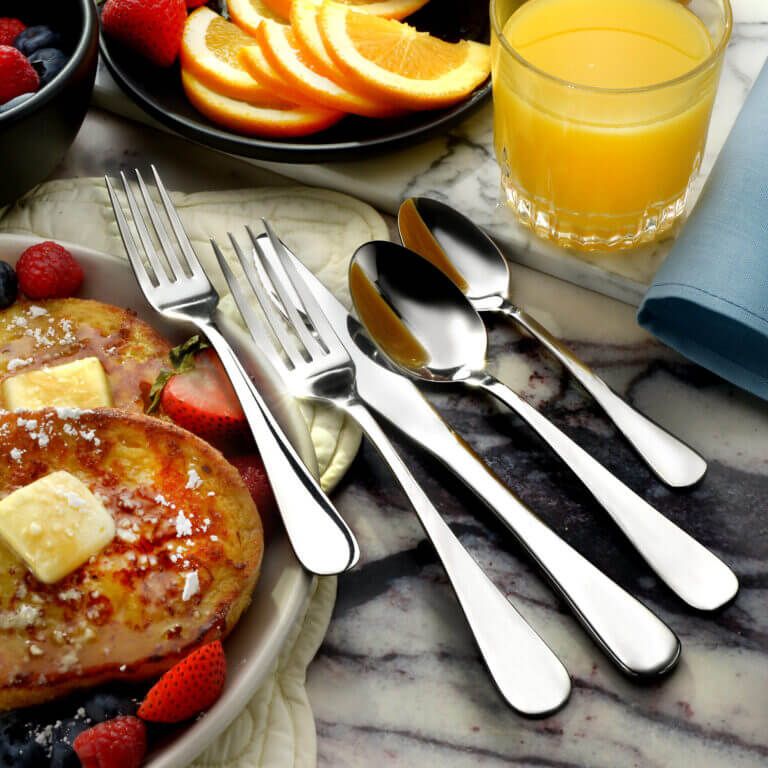 Liberty Tabletop Annapolis flatware set arranged on a navy table setting Liberty Tabletop Annapolis flatware set arranged on a navy table setting