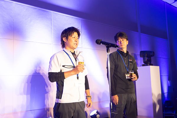 ビールを片手にマイクの前で話をする受賞企業の男性
