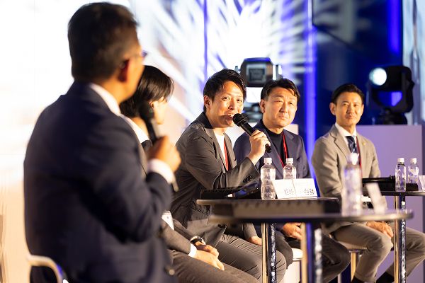 受賞企業がマイクを持って回答している様子