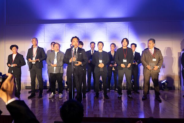 ステージ上で受賞の喜びをコメントする男性