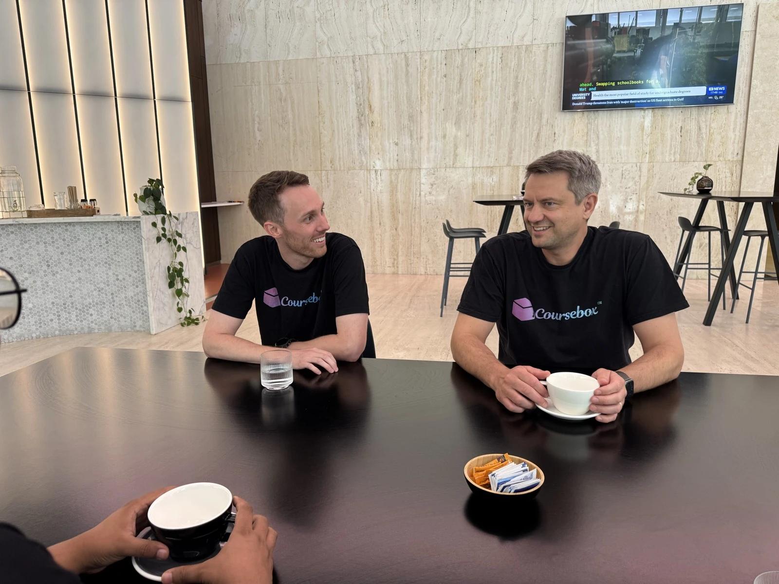 Alex Hey and Travis Clapp in Coursebox T-shirts talking over coffee in the early days of Coursebox