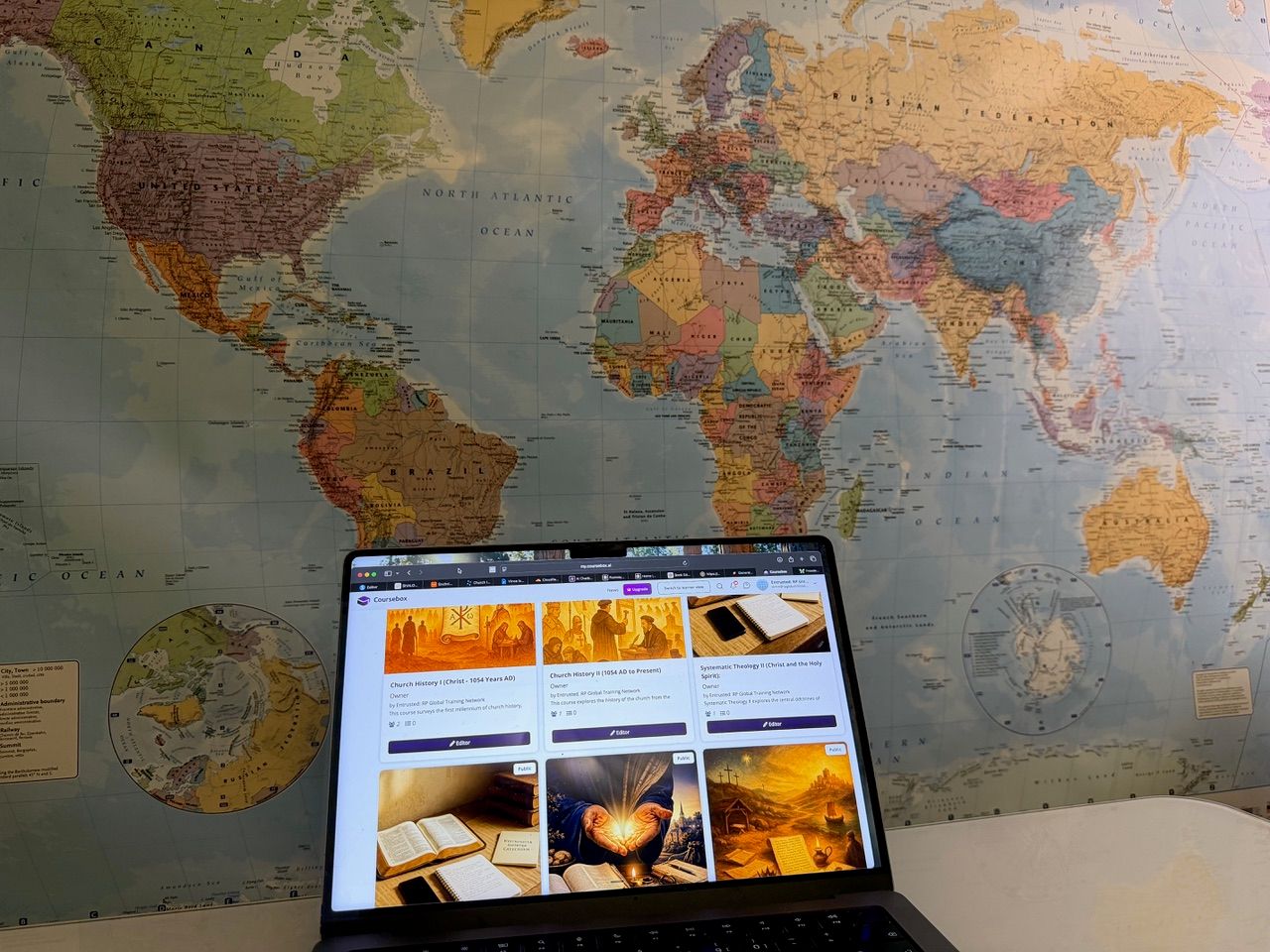 World map with a laptop running Coursebox courses