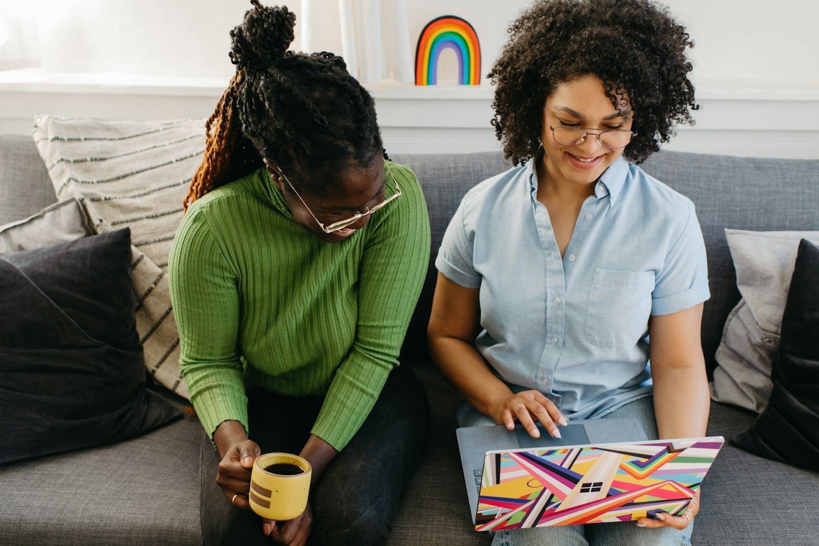 two women on couch watching training video together
