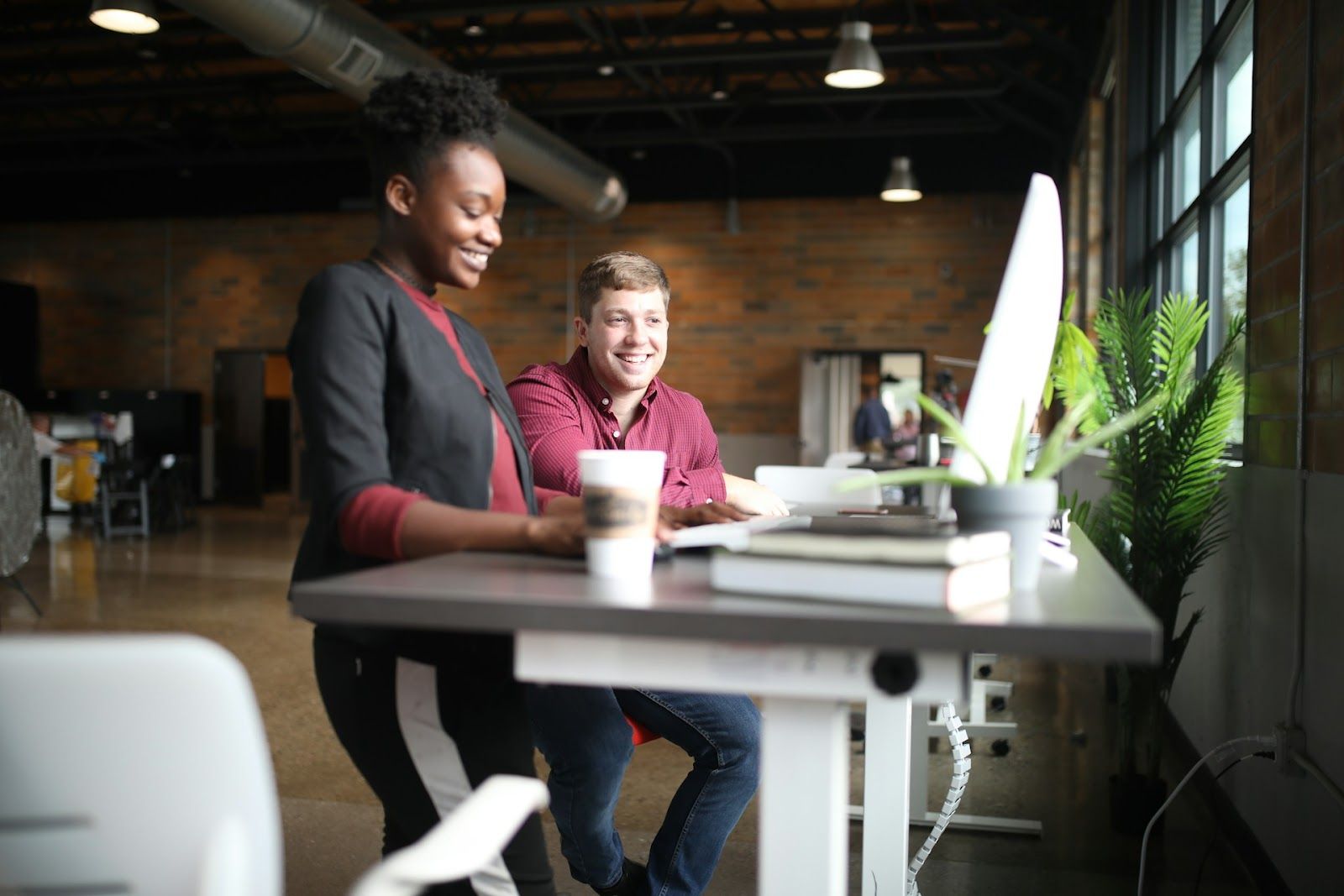 two office workers smiling at computer