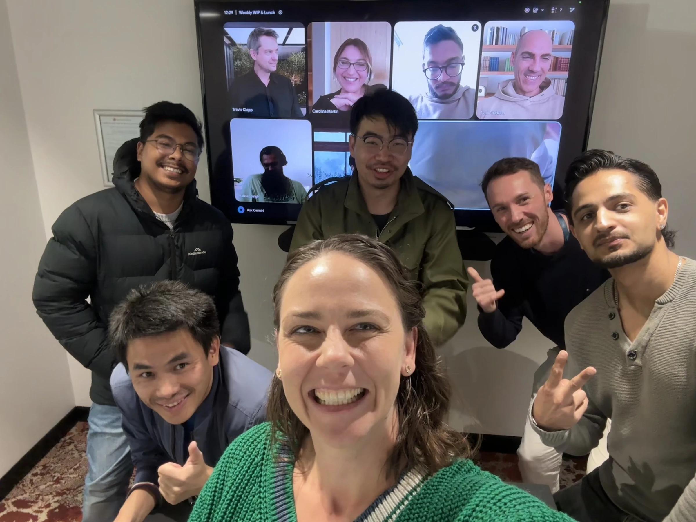 The Coursebox AI team in the Perth office taking a selfie in front of the weekly team meeting call, with remote teammates on the screen