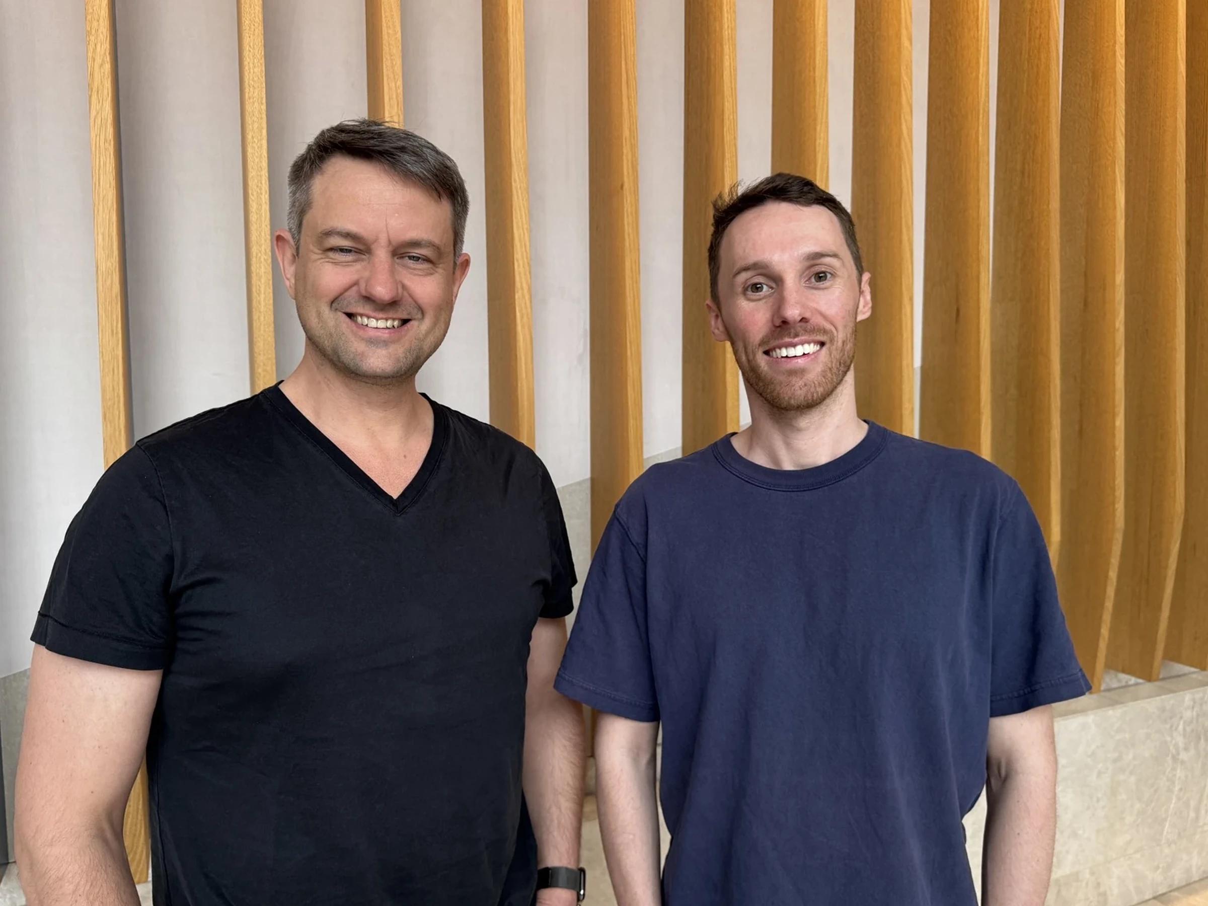 Coursebox co-founders Travis Clapp and Alex Hey smiling side by side in front of a timber slat wall