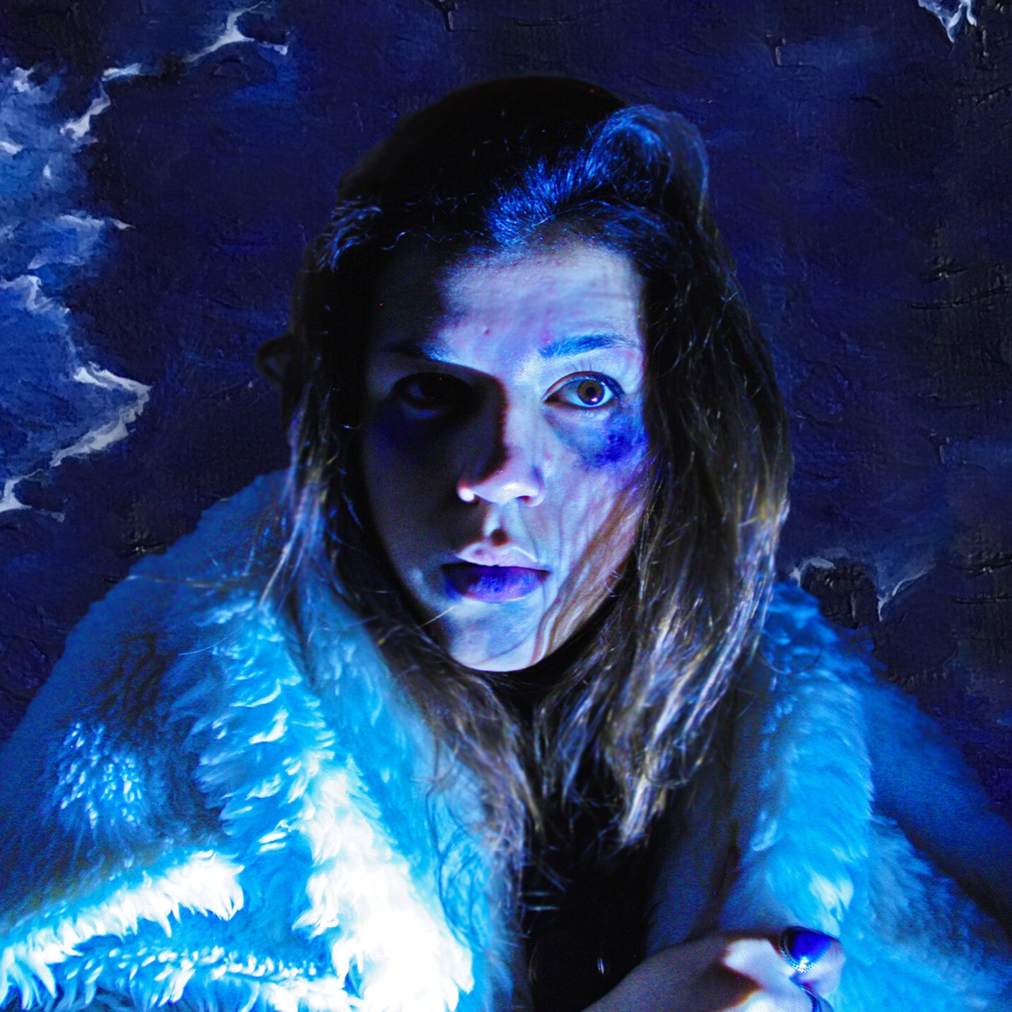 Portrait de Modka en lumière bleue, dans un manteau de fourrure blanche, devant une toile peinte.