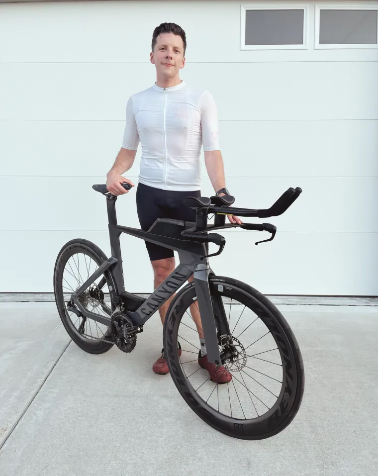 Man posing with a tri bike