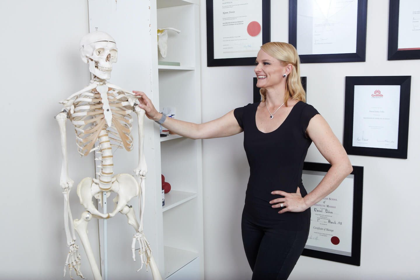 Karen Finnin standing next to a medical model of a human skeleton