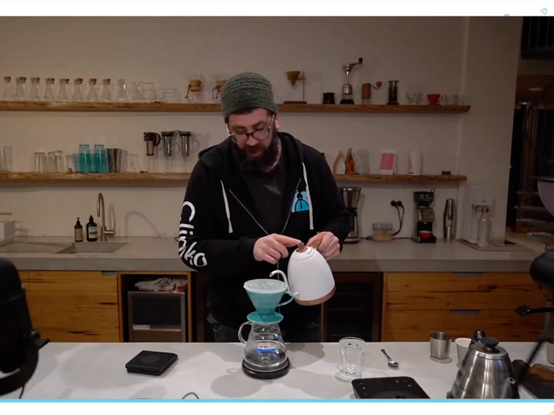 A screenshot of Joel pouring hot water from a kettle into his V60 to brew pour over coffee