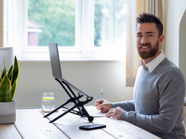 A photo of Tim Barsellotti taking notes in front of a laptop while working at home.