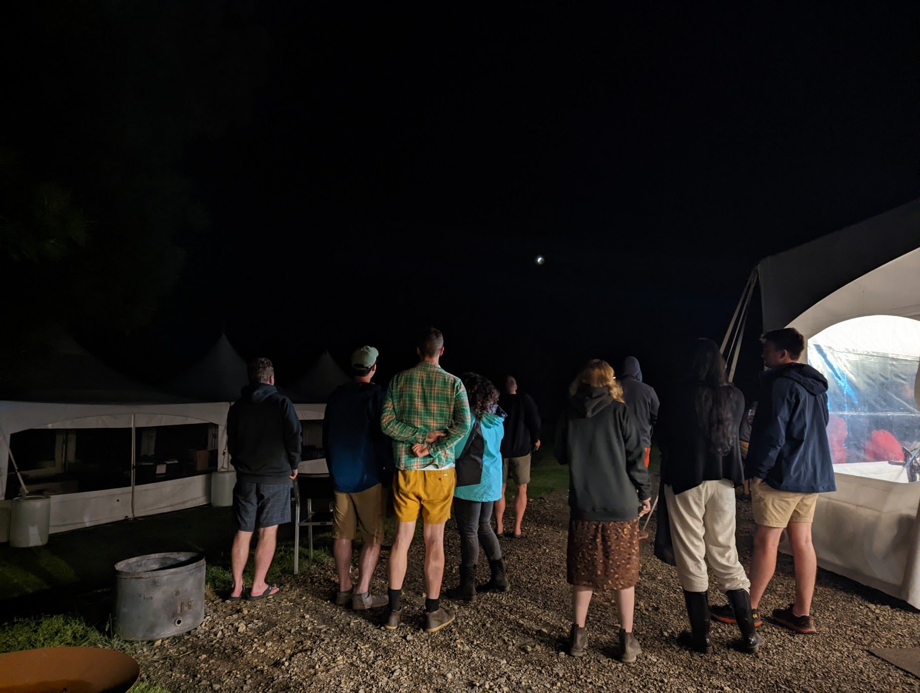 A photo of a group gathered outside a marquee watching the lunar eclipse 