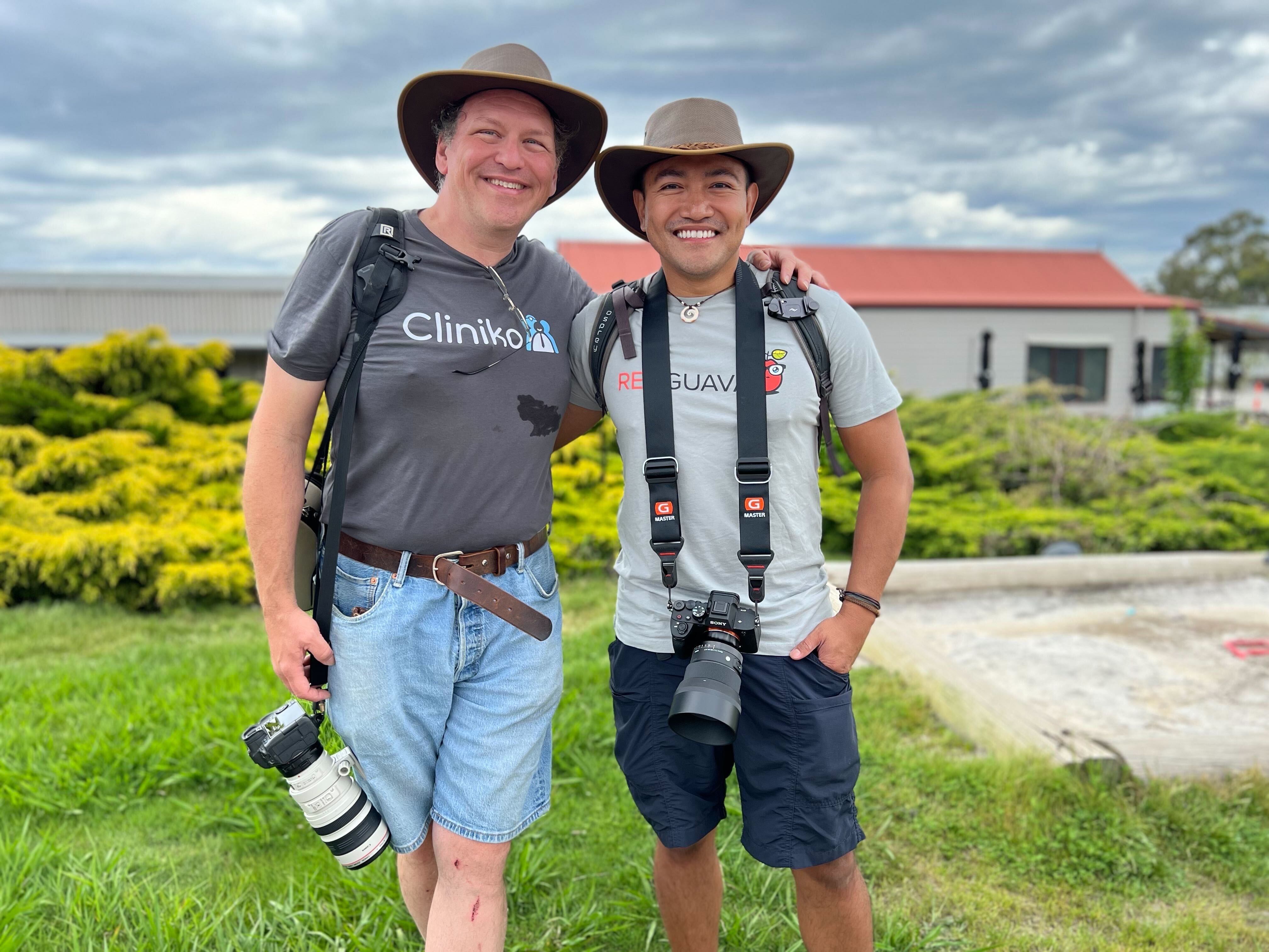 Bill and a colleague with matching hats and cameras