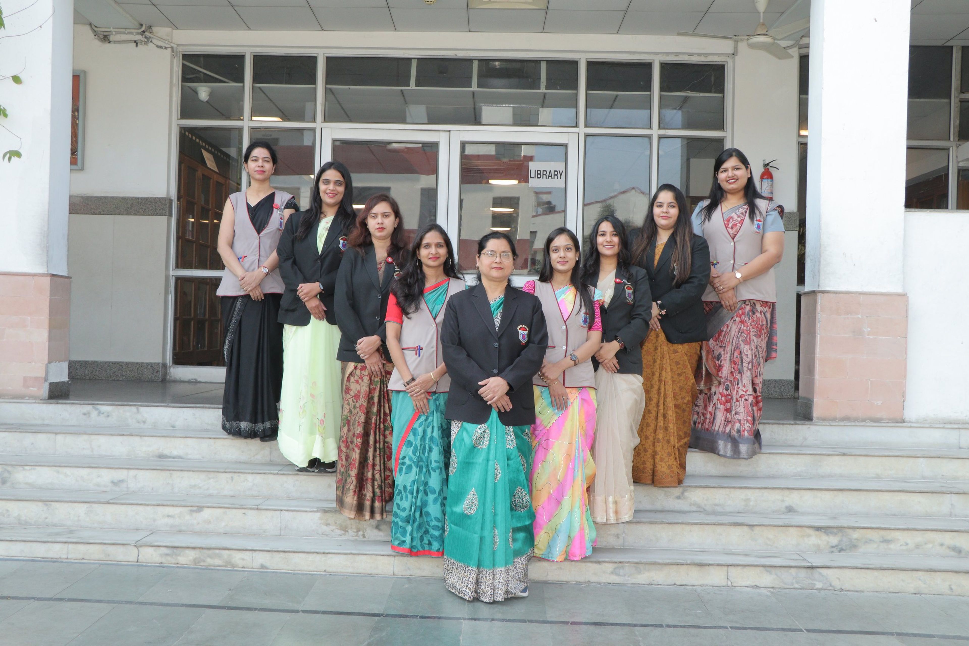 Teachers standing together on the steps of the school entrance