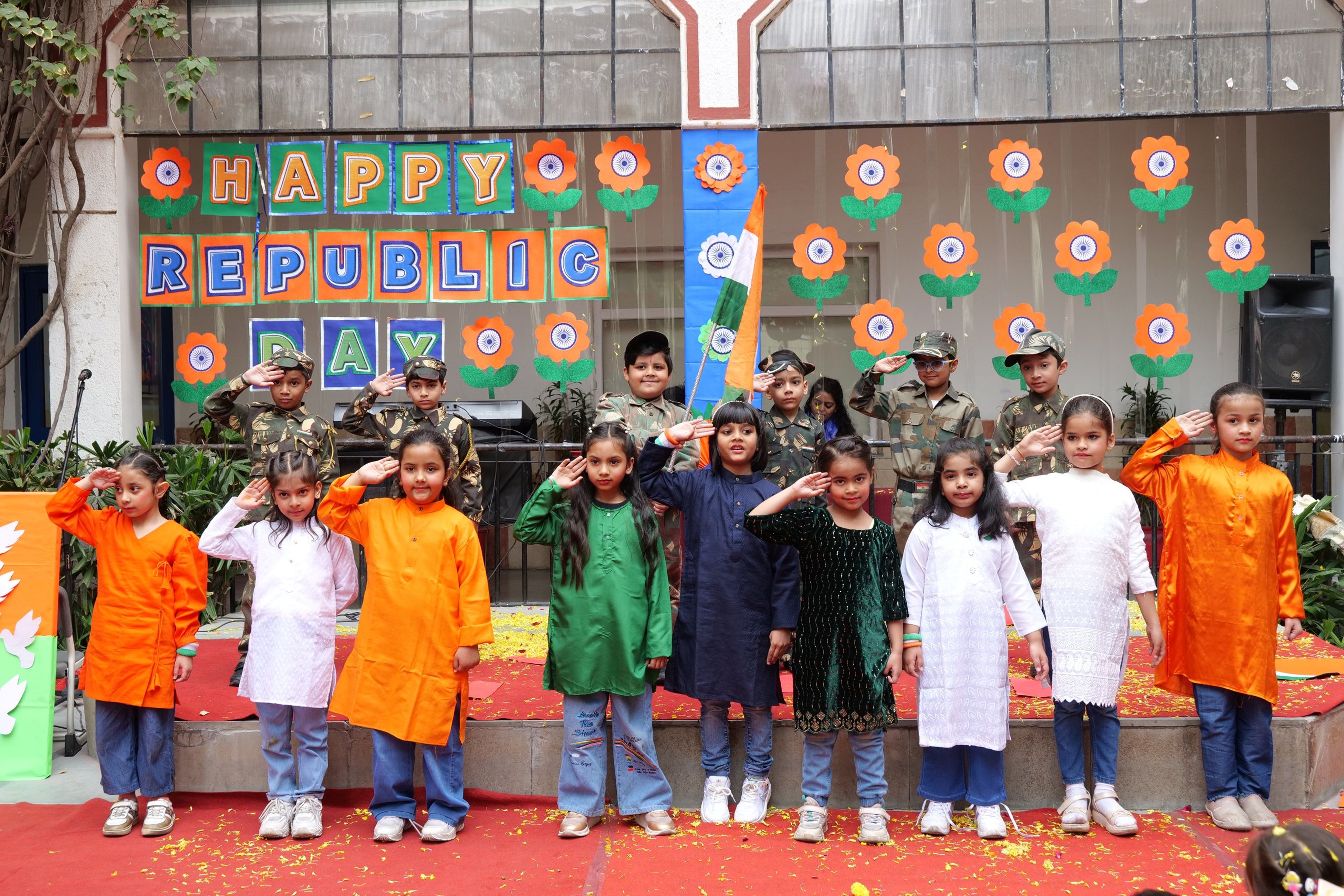 Pupils in tricolour outfits saluting at the Republic Day celebration