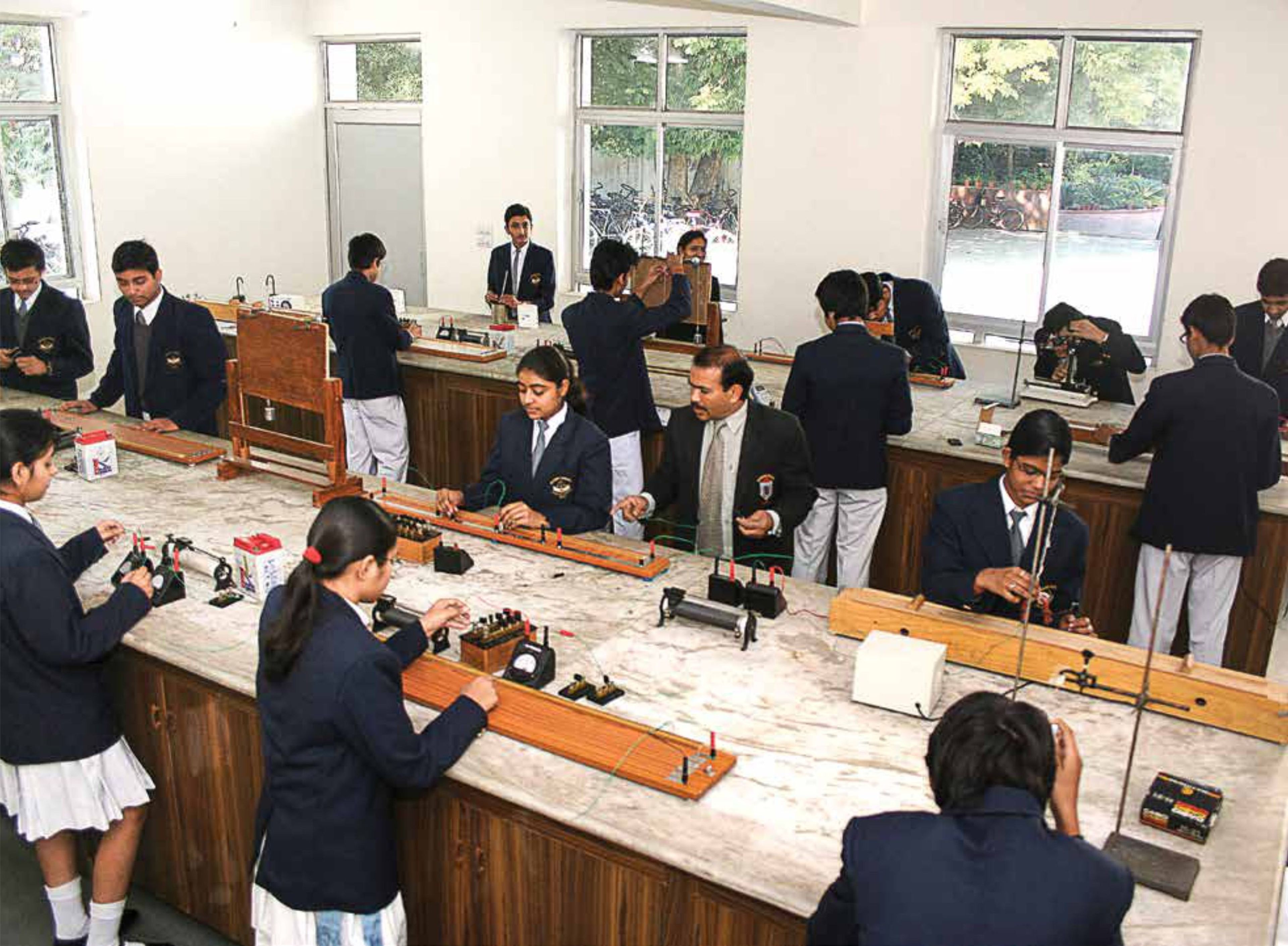 Students working in the physics lab with their teacher